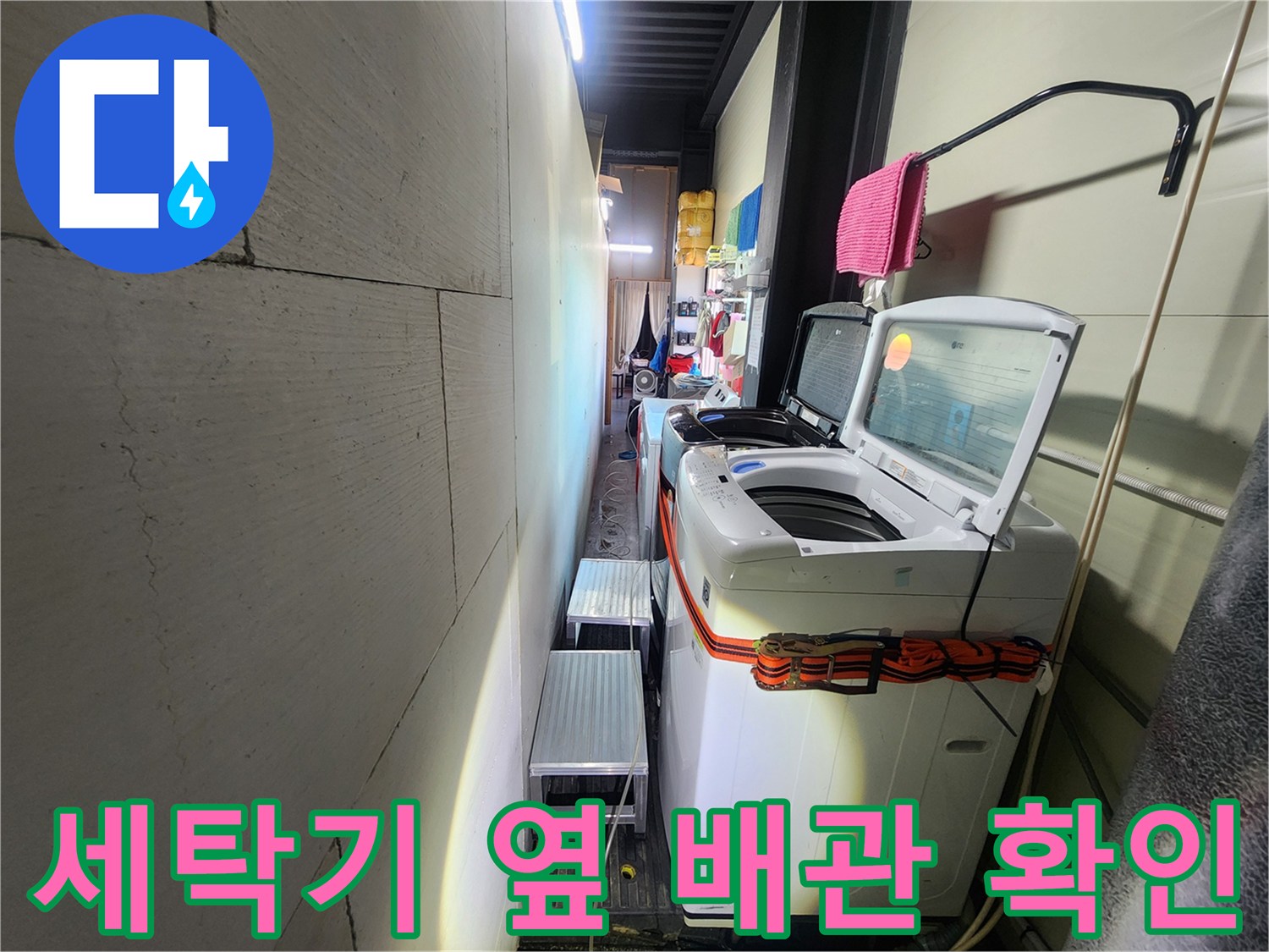 세탁실 좁은 통로-배관 연결부 점검 중