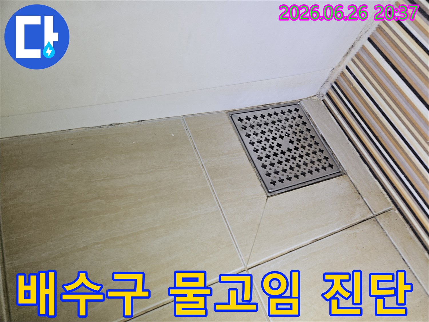 욕실 배수구 주변의-타일과 줄눈에-나타난 어두운 흔적은-지속적인 물고임이나-물 스밈으로 인한-누수 가능성을-보여줍니다
