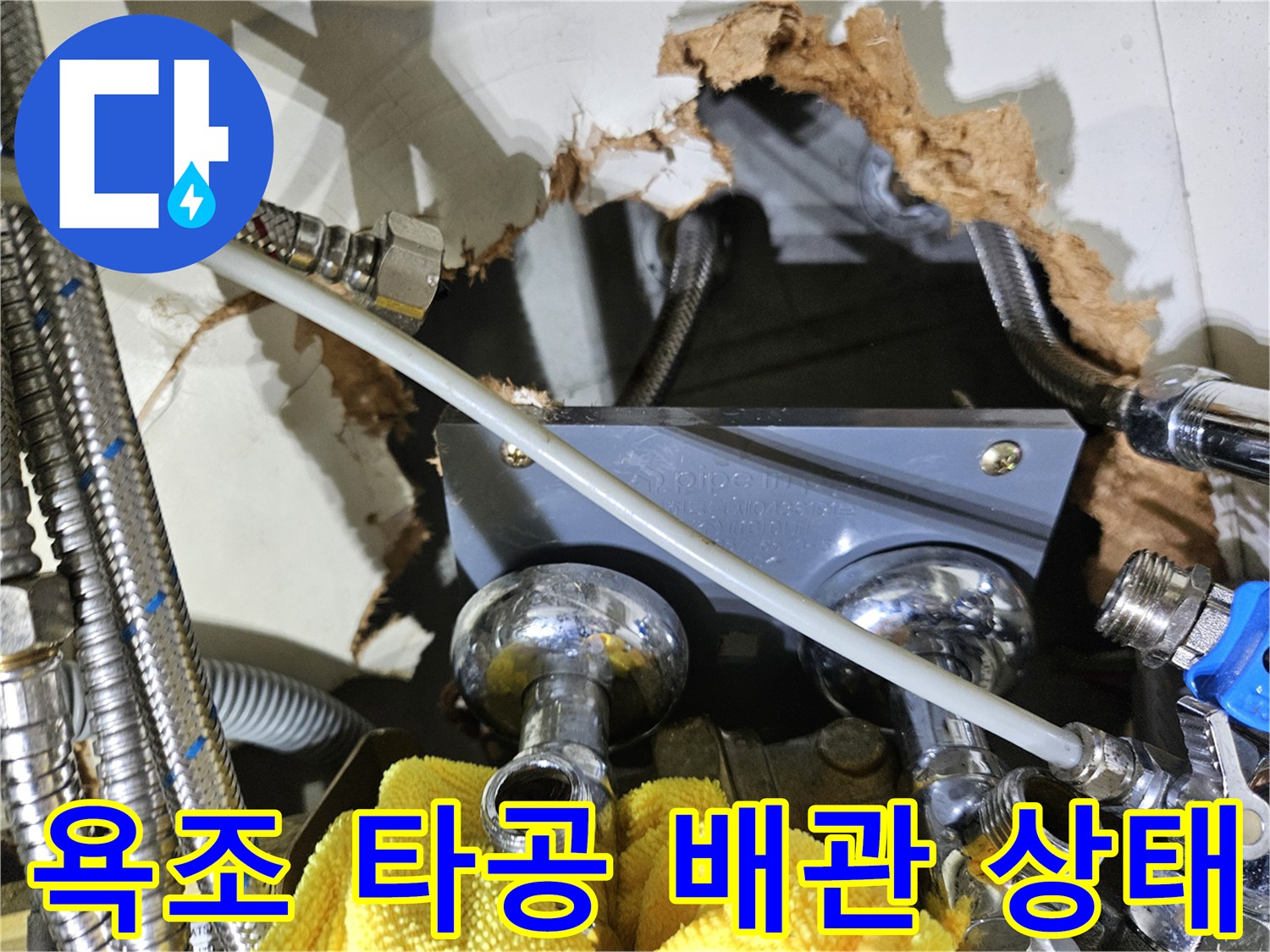 금속 배관과 연결 부속이 노출된 욕조 내부 타공 부위