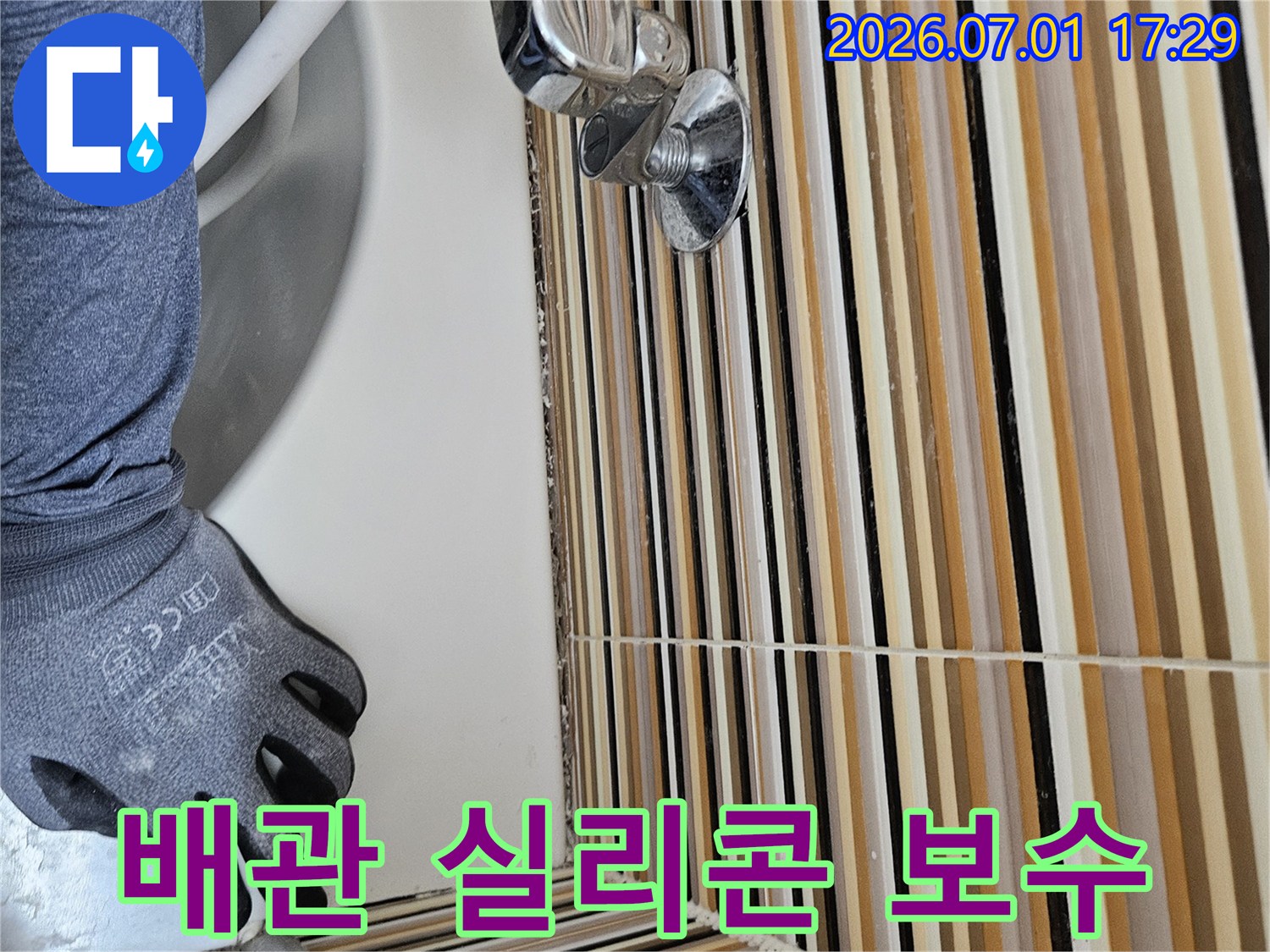숙련된 기술자가-세면대 배수관 주변-오래된 실리콘을 제거하고-새롭게 보수하는 작업 현장