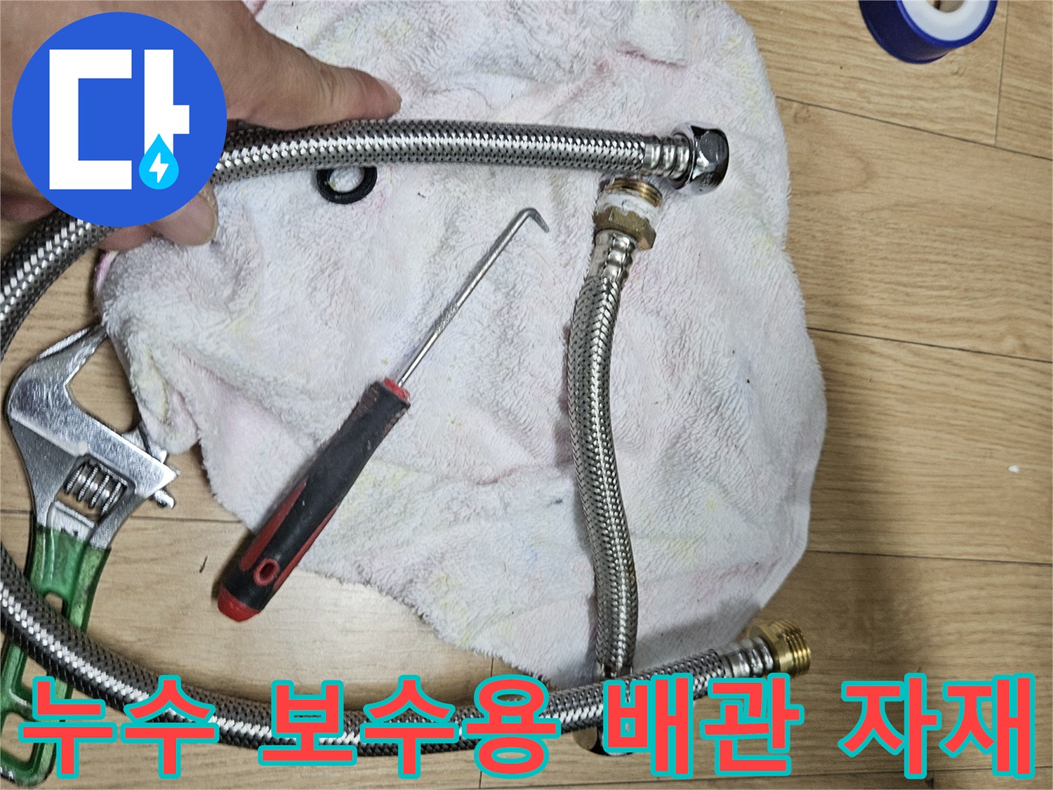 작업을 위해 나열된 은색 주름관과 렌치 및 테이프