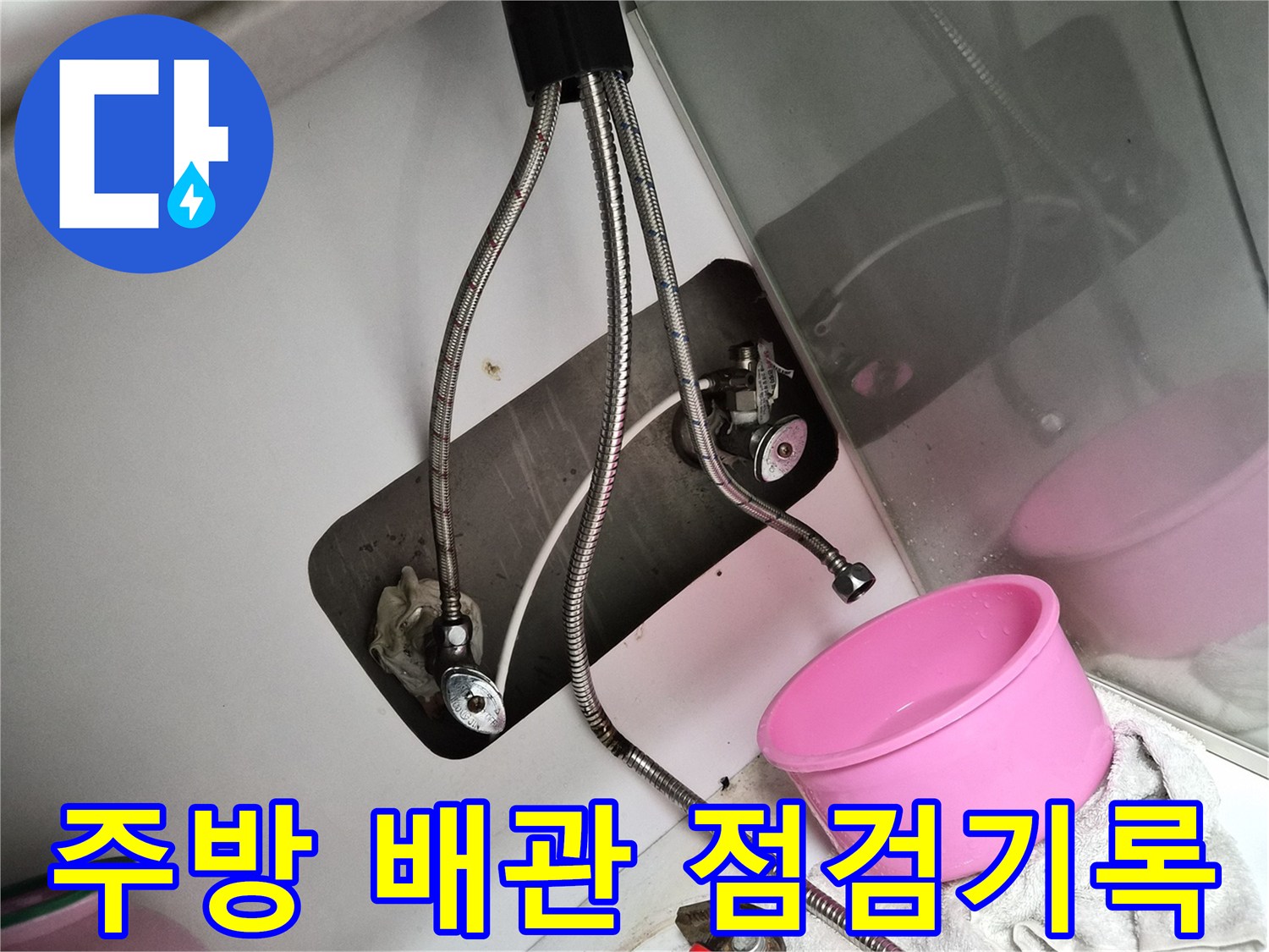 싱크대 하부장 내부의 밸브와 호스 연결 부위 상세 사진
