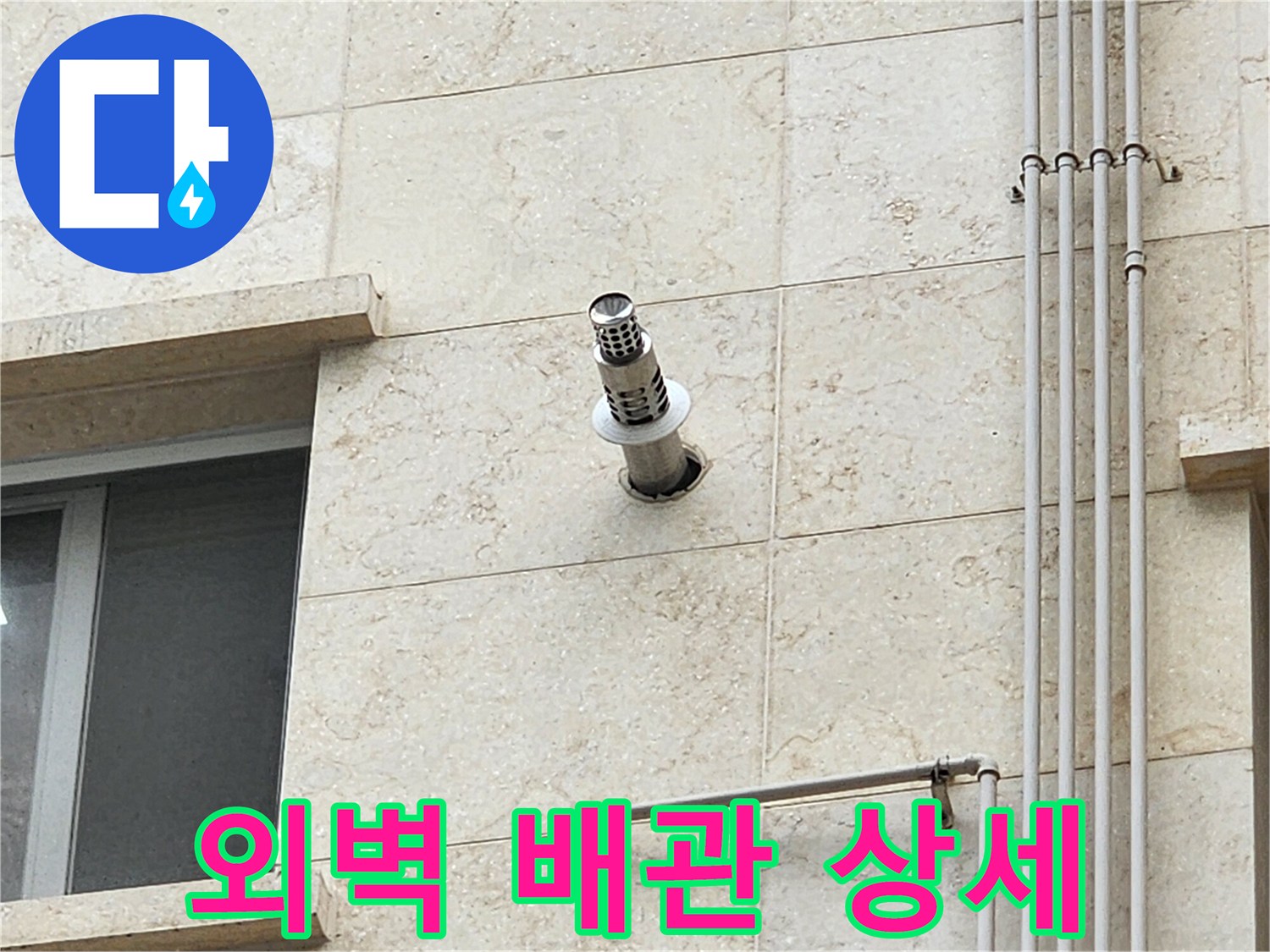 석재 벽면에 설치된 스테인리스 구조물과 수직 관의 연결 부위