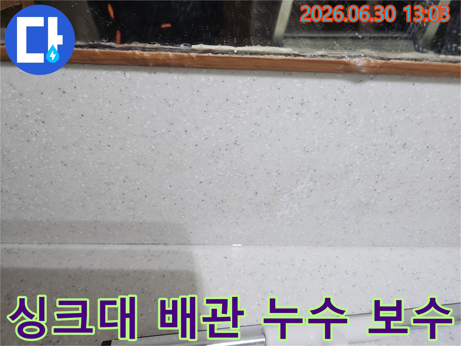 싱크대 주변-벽면에서-발견된-미세한 물자국을 통해-배관 누수를 의심하고-신속한 보수를 준비하는 장면