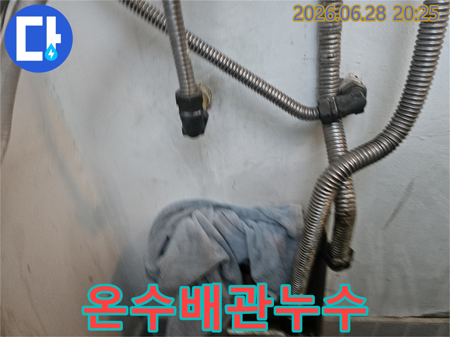 온수 배관에서-누수가 의심되어-배관 주변을-정밀하게 점검하고-물기를 닦아낸-수건이 놓인-현장 모습