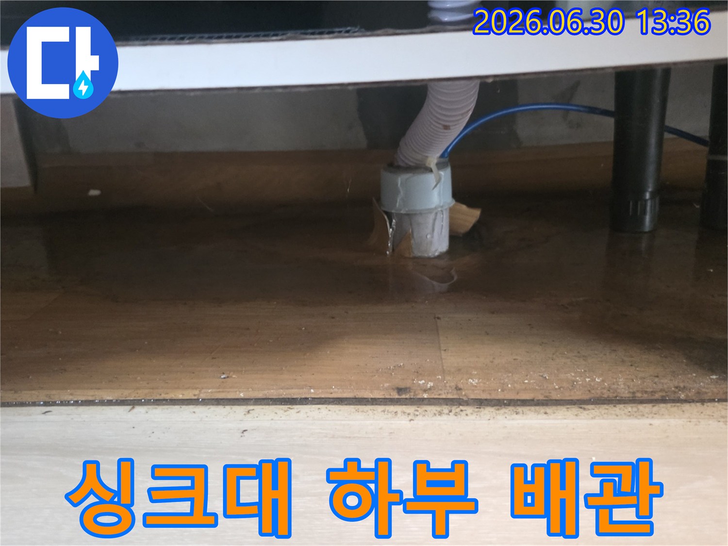 싱크대 하부 배수관 연결 부위에서 물이 새어-바닥에 고여있는-누수 현장의 모습입니다.