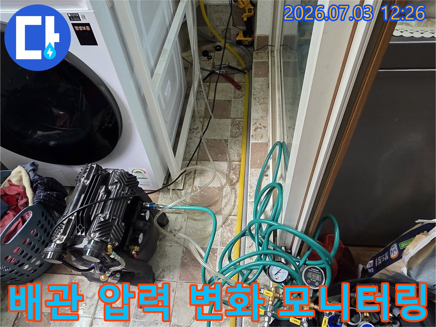 세탁기 옆 공간에 설치된 장비들로 배관의 기밀성을 확인하는 정밀 점검 공정