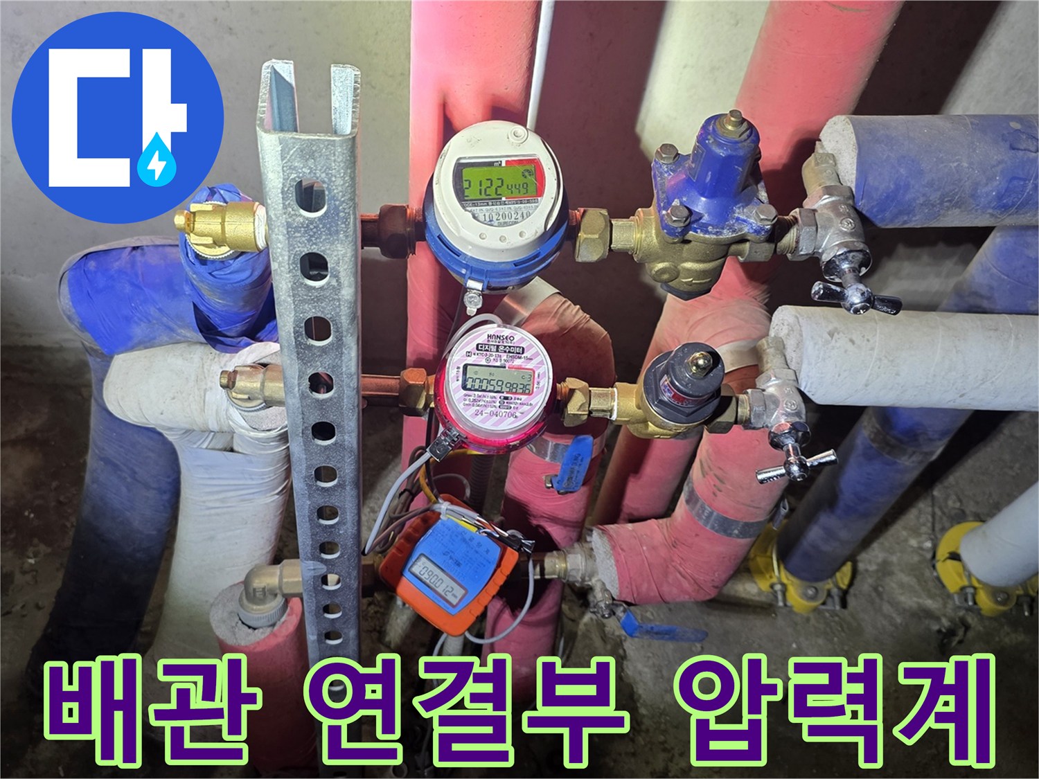 분홍색 보온재로 감싸진 배관과 측정용 게이지 장비