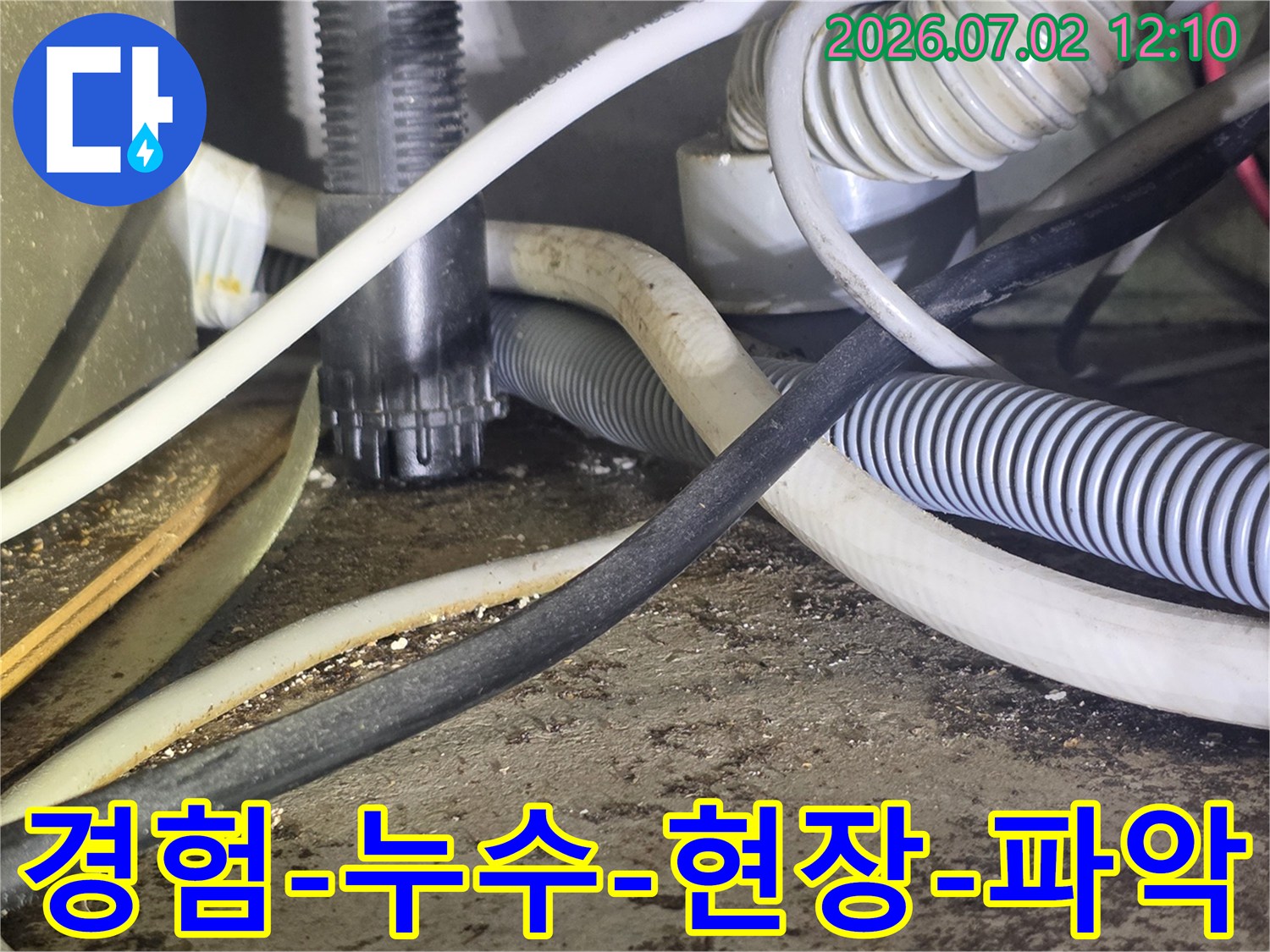 이 이미지는-숙련된 누수 엔지니어가-복잡한 배관과-전선 사이에서-누수 현장을-면밀히-파악하는-모습을 보여줍니다.