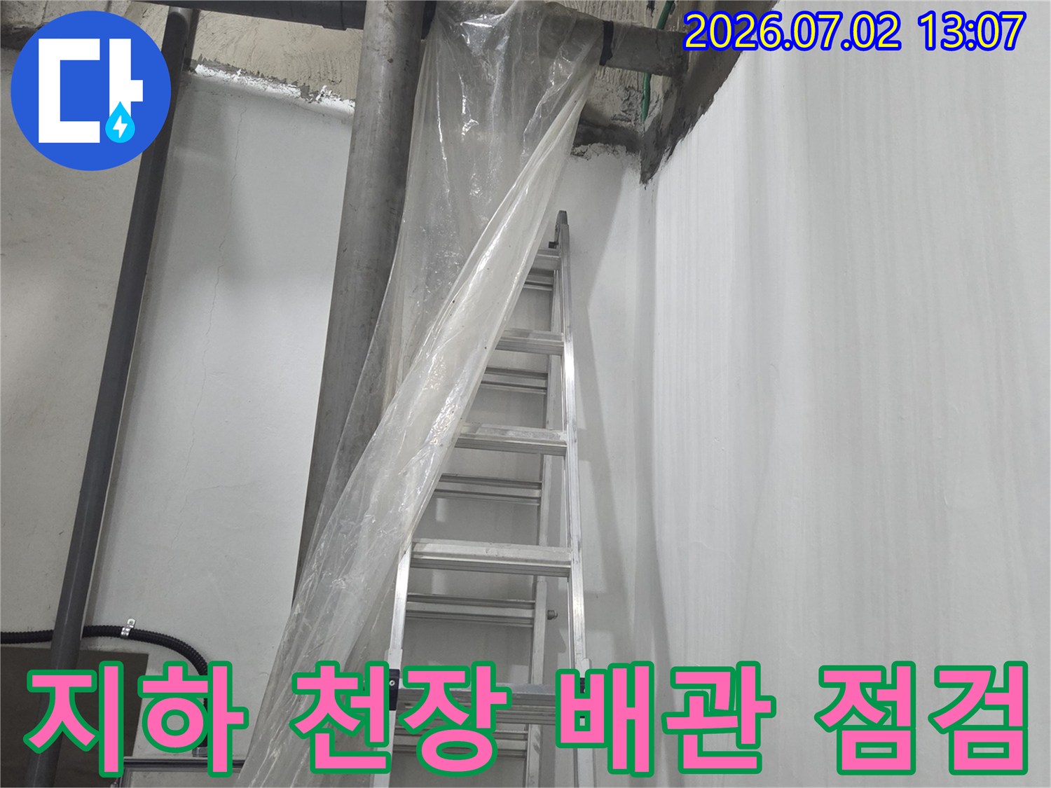 지하 공간의 복잡한 배관 라인과 천장 부위-누수 진단을 위해 설치된 사다리 모습