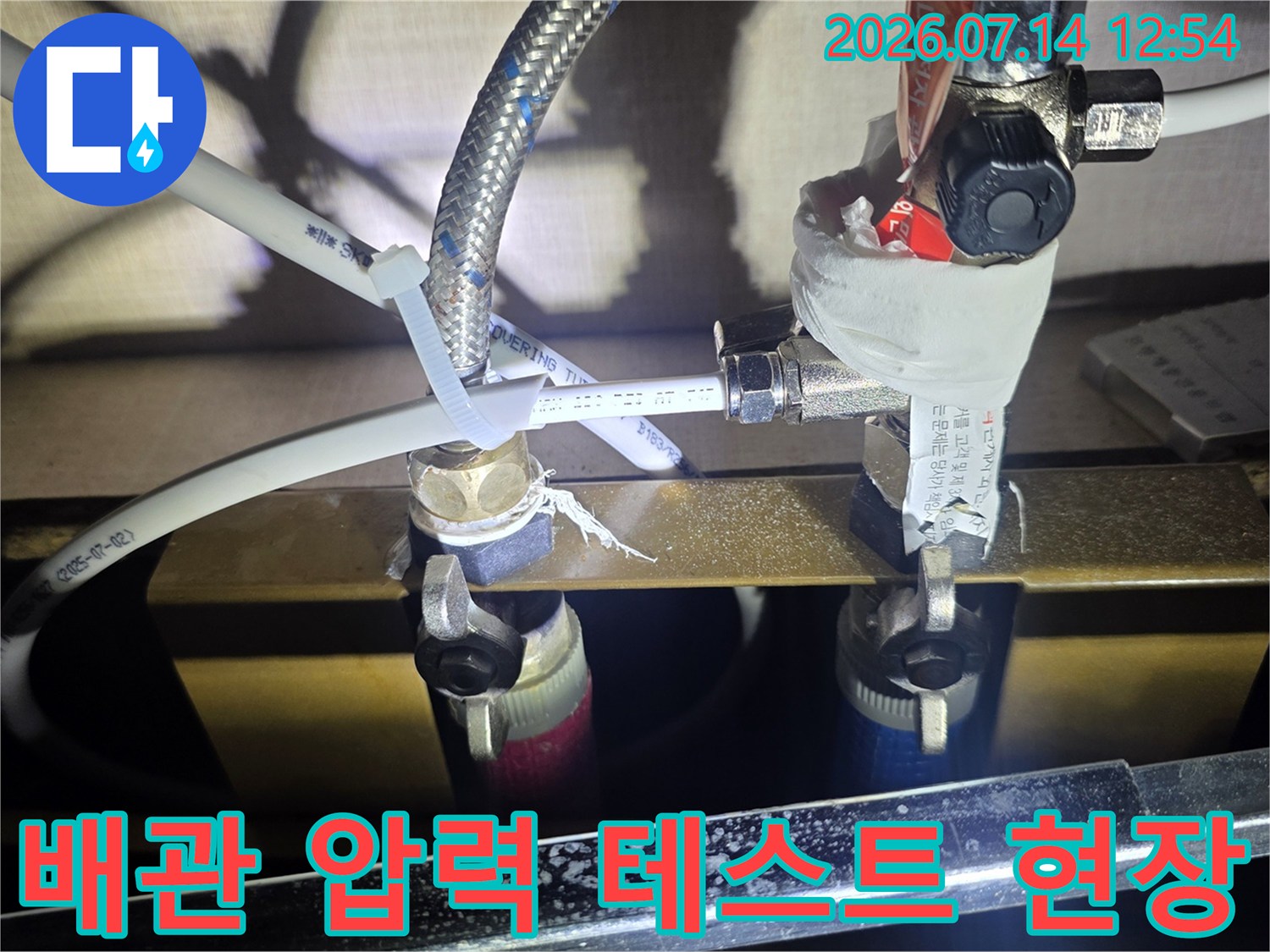 싱크대 아래 배관 연결부에 장비를 설치하여 누수 여부를 정밀하게 확인하는 사진