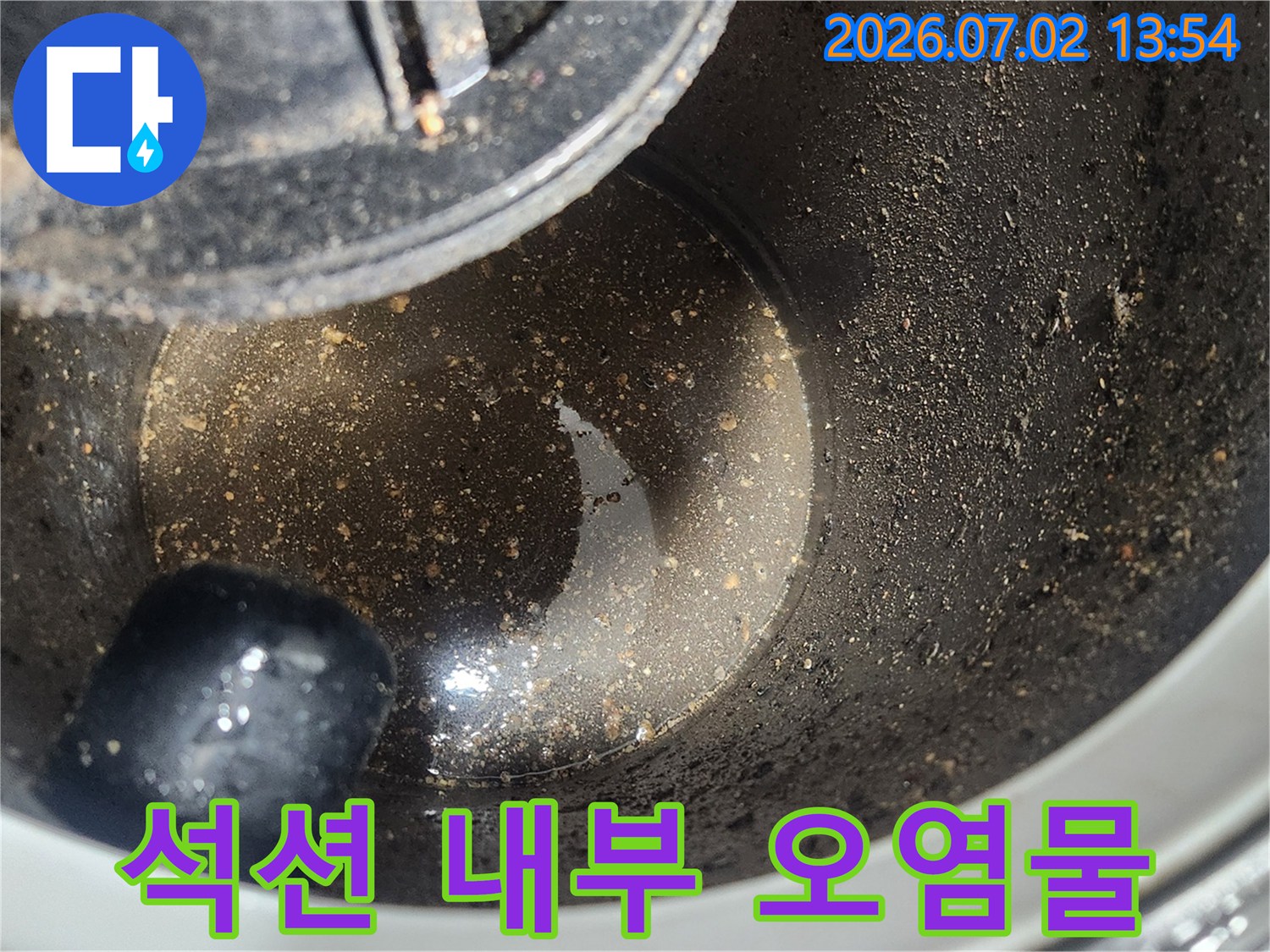 배관 스케일링 1차 작업 후-석션 장비 내부에 포집된-굳은 기름층과 오염물질을 보여주는 클로즈업 사진
