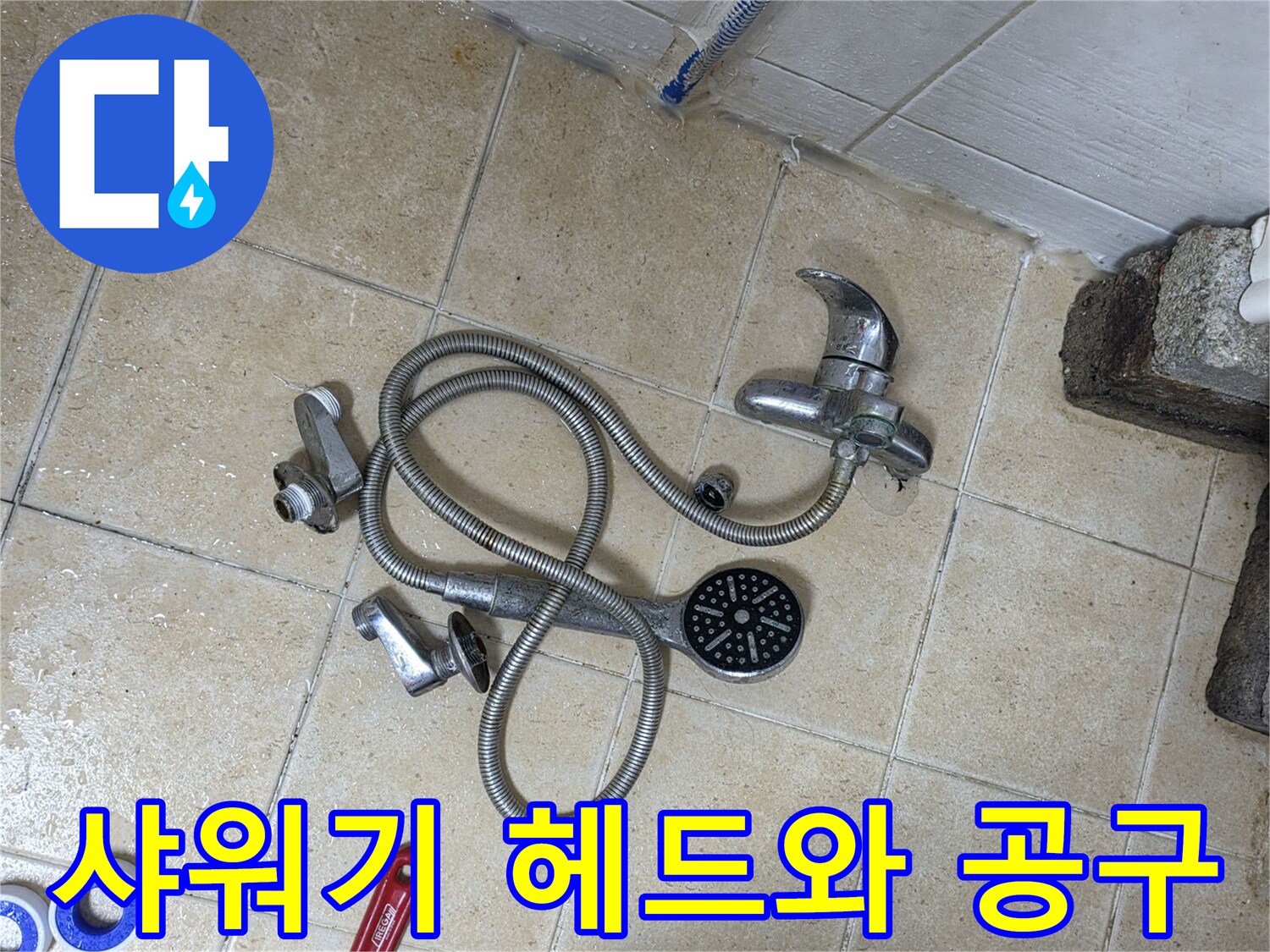 공사 현장 바닥의-분해된 샤워기 부속과 몽키스패너