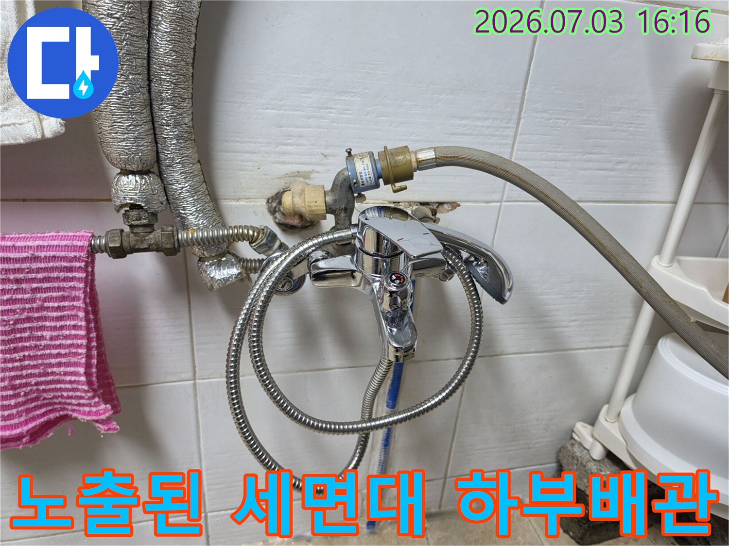 세면대 아래에 설치된 금속 재질의 배관과 연결 호스 구조