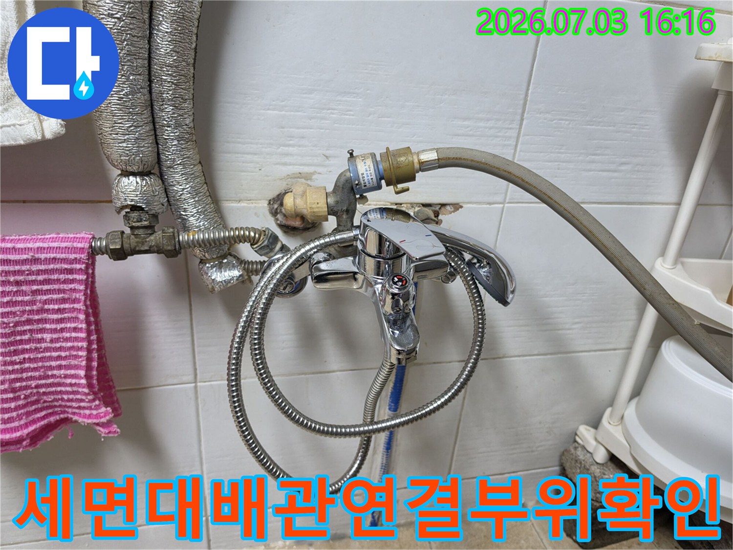 세면대 아래쪽 배관 연결 부위와 수전 호스 상태를 점검하는 모습