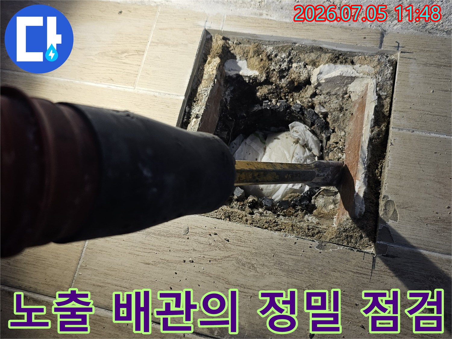 타일이 제거된 공간에서 장비를 이용해 노후 배관을 세부적으로 검사하는 현장 사진