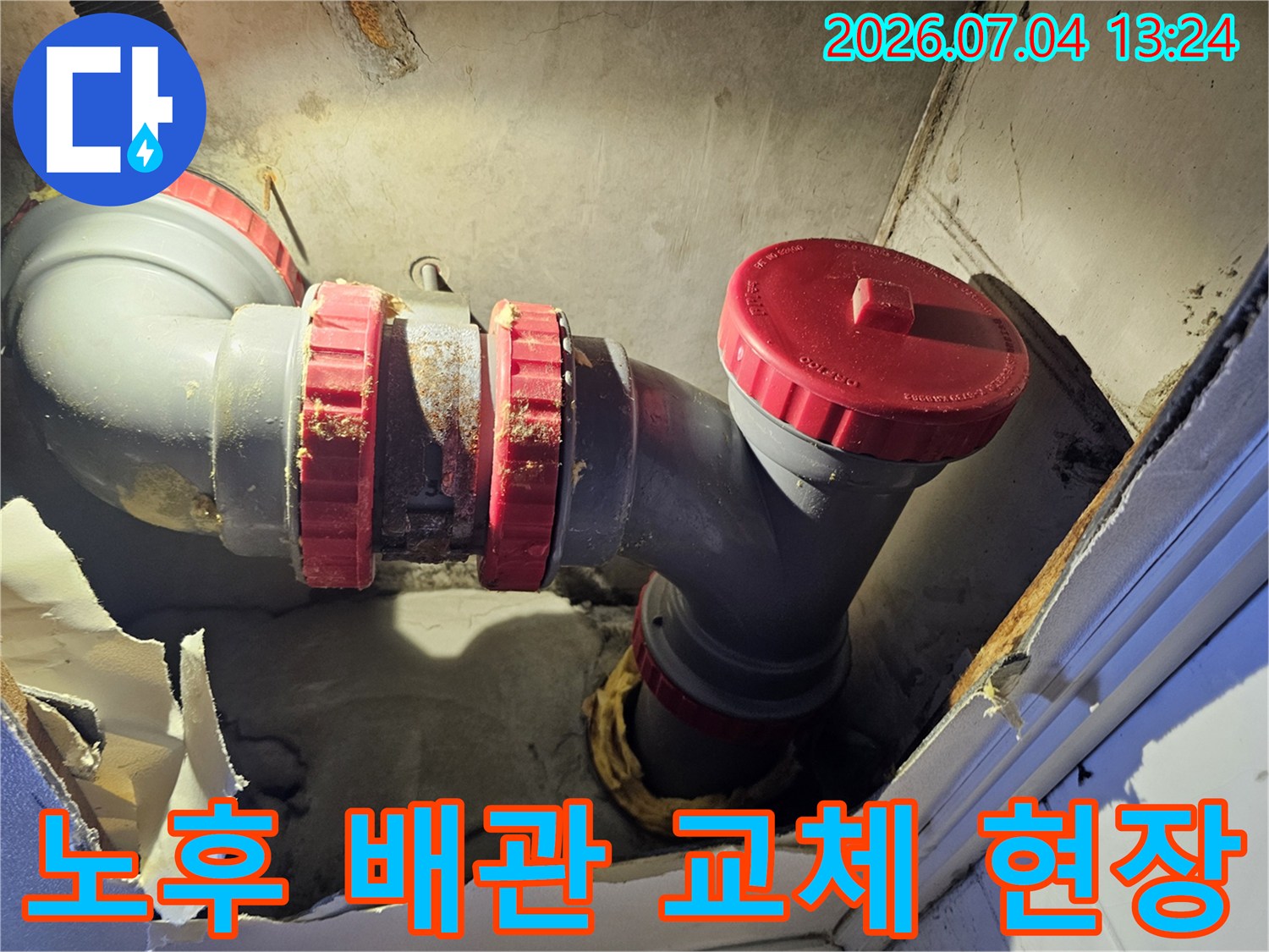 상단이 노출된 배관 연결부와 붉은색 보호캡이 씌워진 트랩 구간