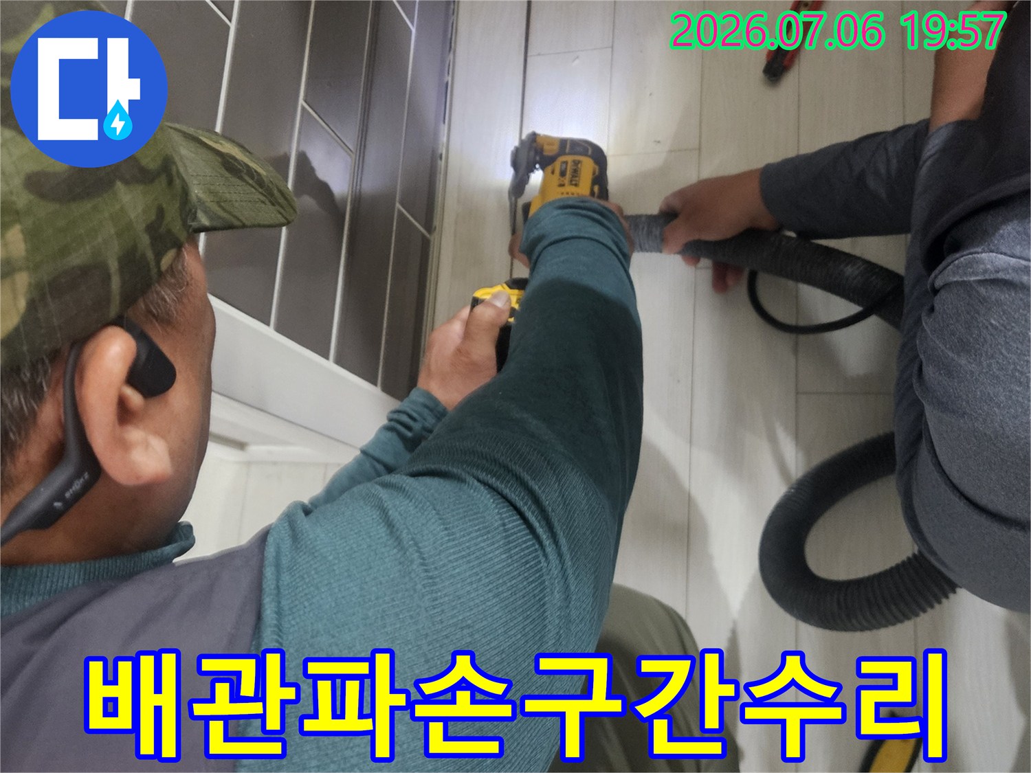 작업자가 전동 공구를 사용하며 배관 수리 작업을 진행하는 모습