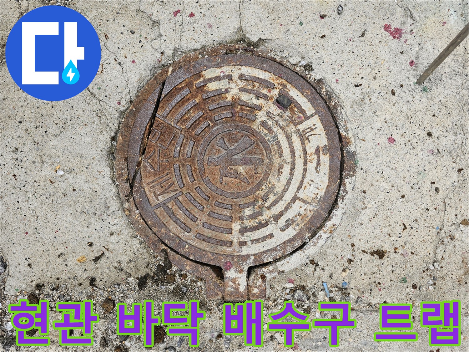 낡은 금속제 배수구 덮개와 주변의 거친 시멘트 질감 사진