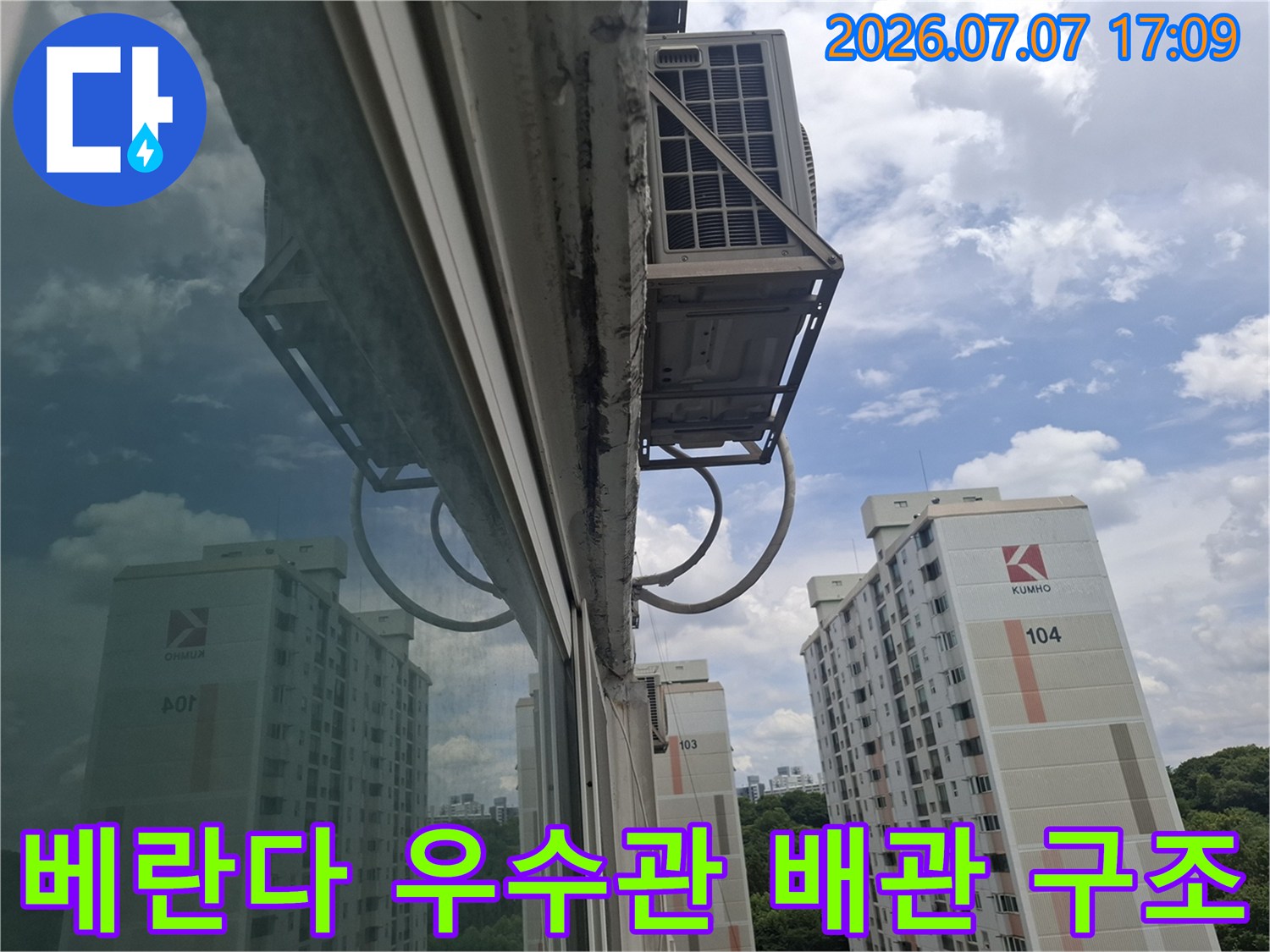 베란다 창문 밖으로 노출된 우수관 시스템과 아파트 외벽 배경