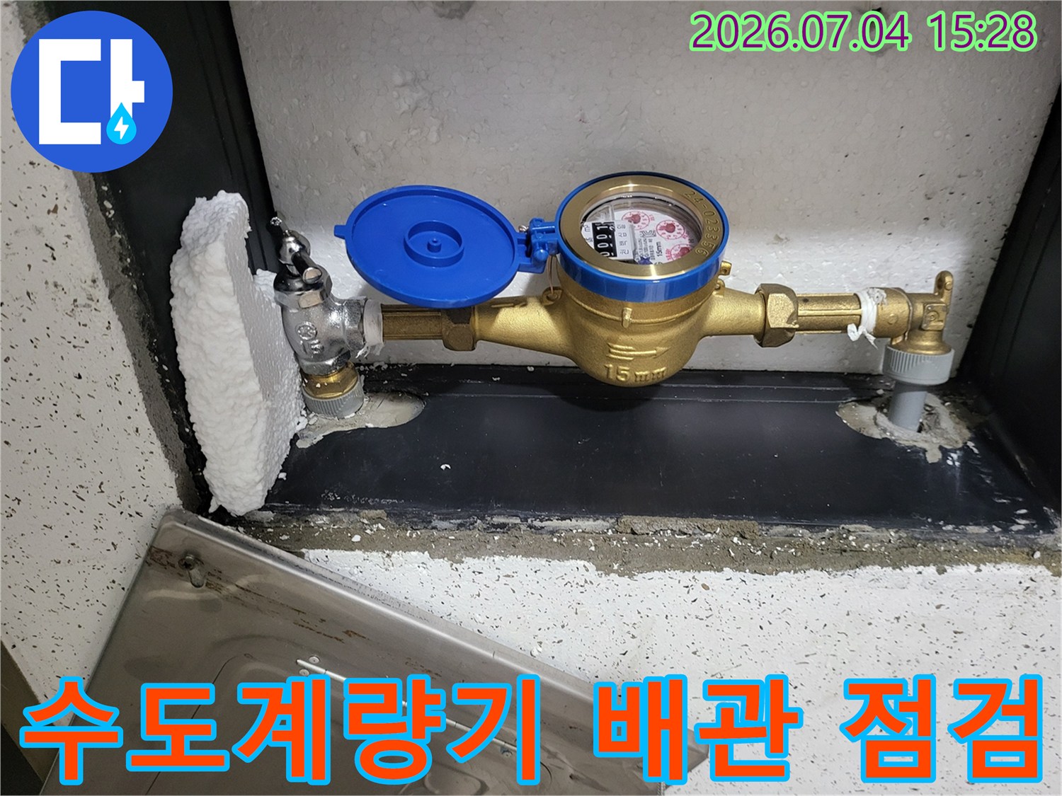 노란색 수동 계량기가 설치된 수도 배관과 연결 부위 점검 모습