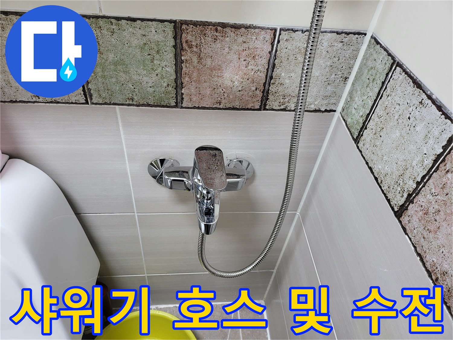 메탈 소재의 샤워기 호스가 연결된 욕실 수전 상세 사진
