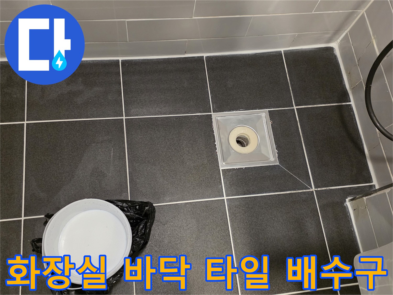 회색 타일 사이의 배수구 유가 주변부 근접 사진입니다.