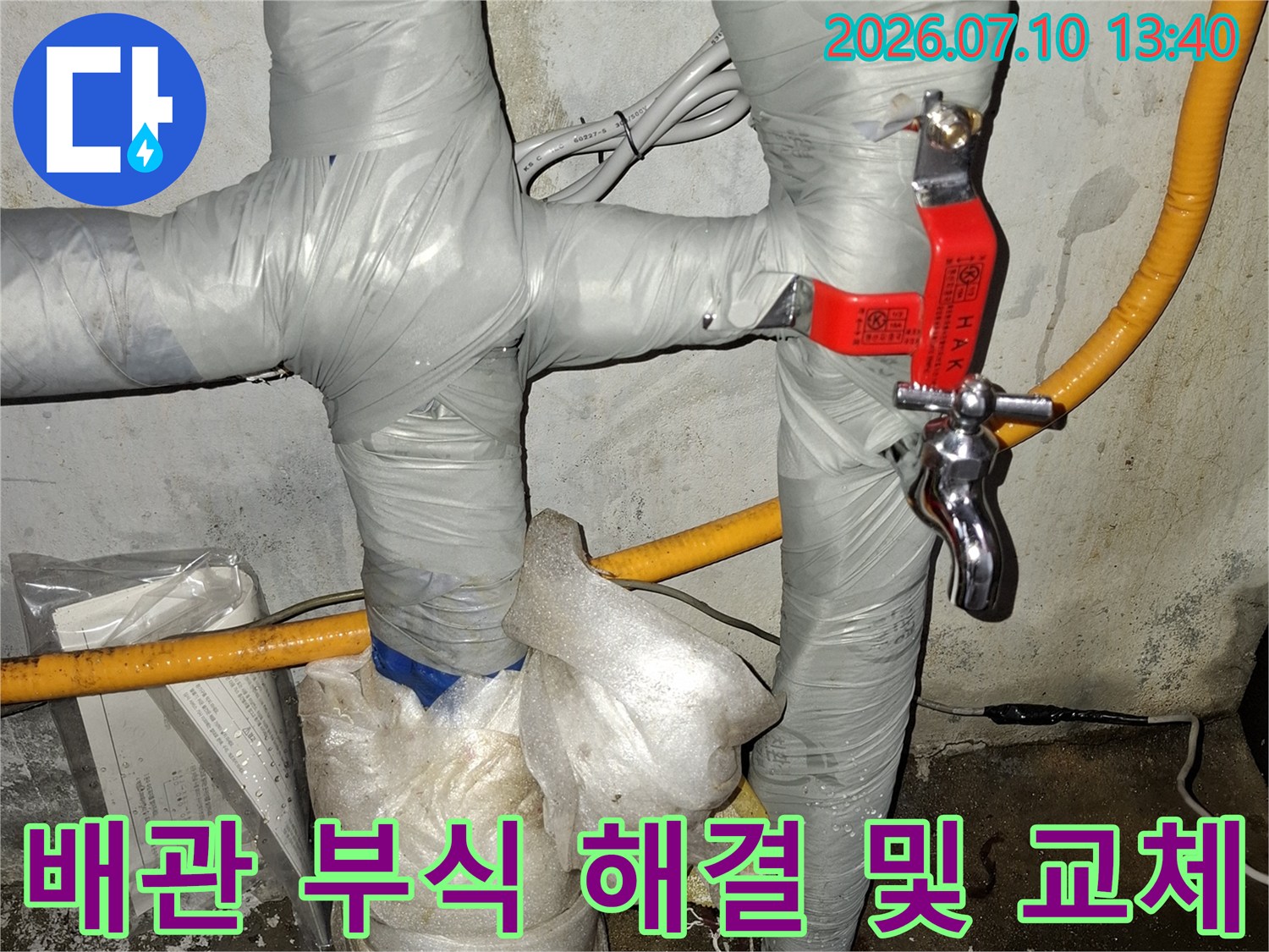 보온재로 덮인 배관 구조에서 노후된 금속 연결부와 신규 설치된 밸브의 모습