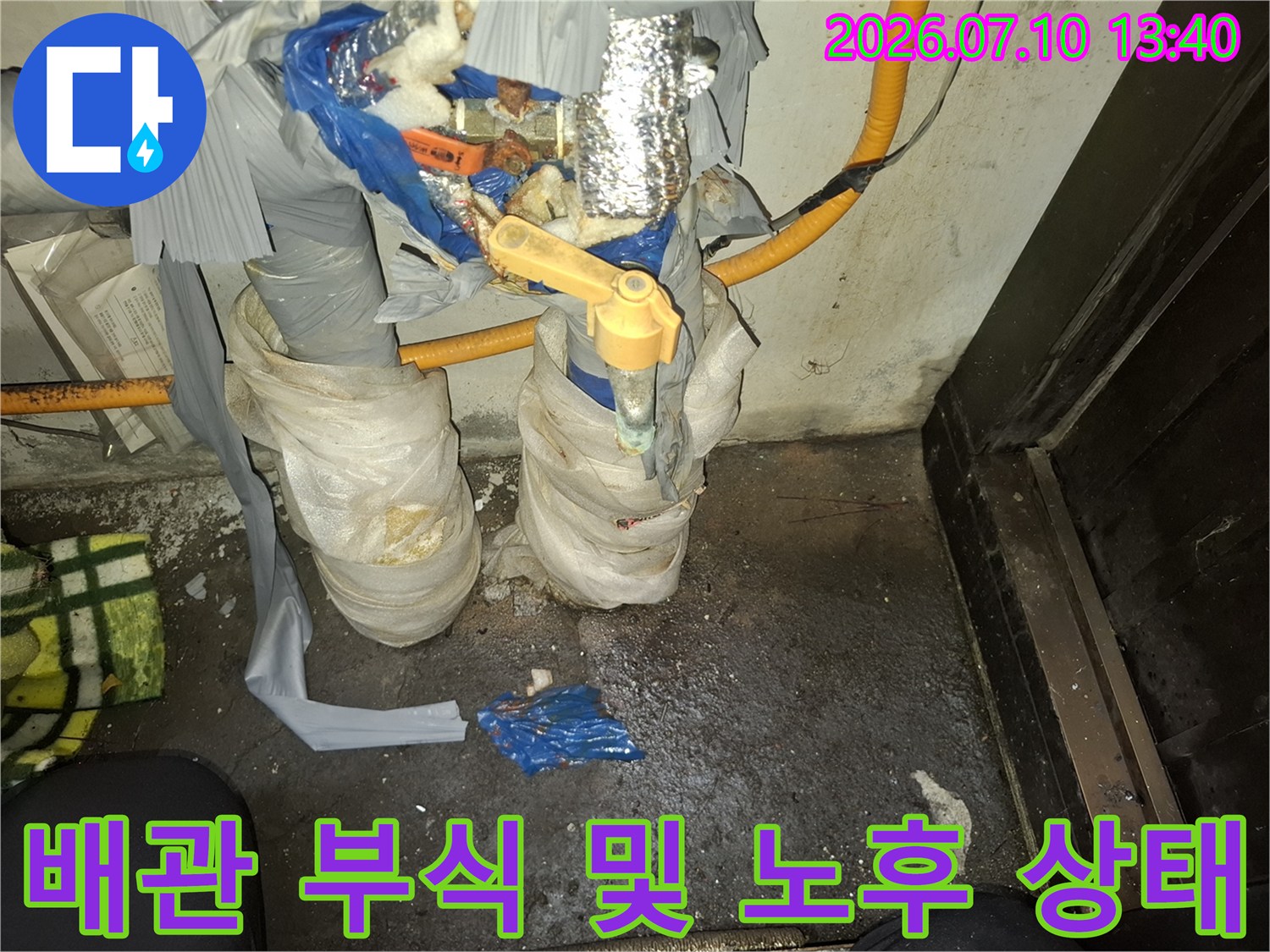 부식이 심한 배관과 젖은 보온재가 있는 지하 현장 모습