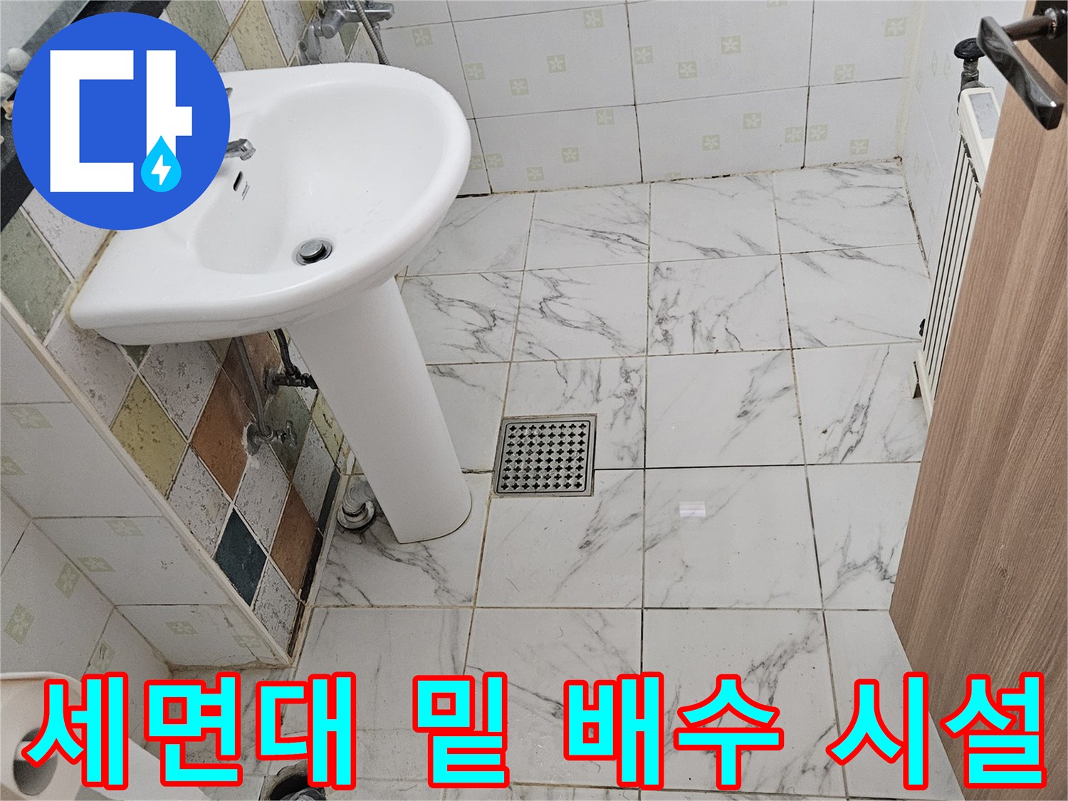 세면대 하단부의 배수관과 벽면 타일 경계 부위 상세 사진