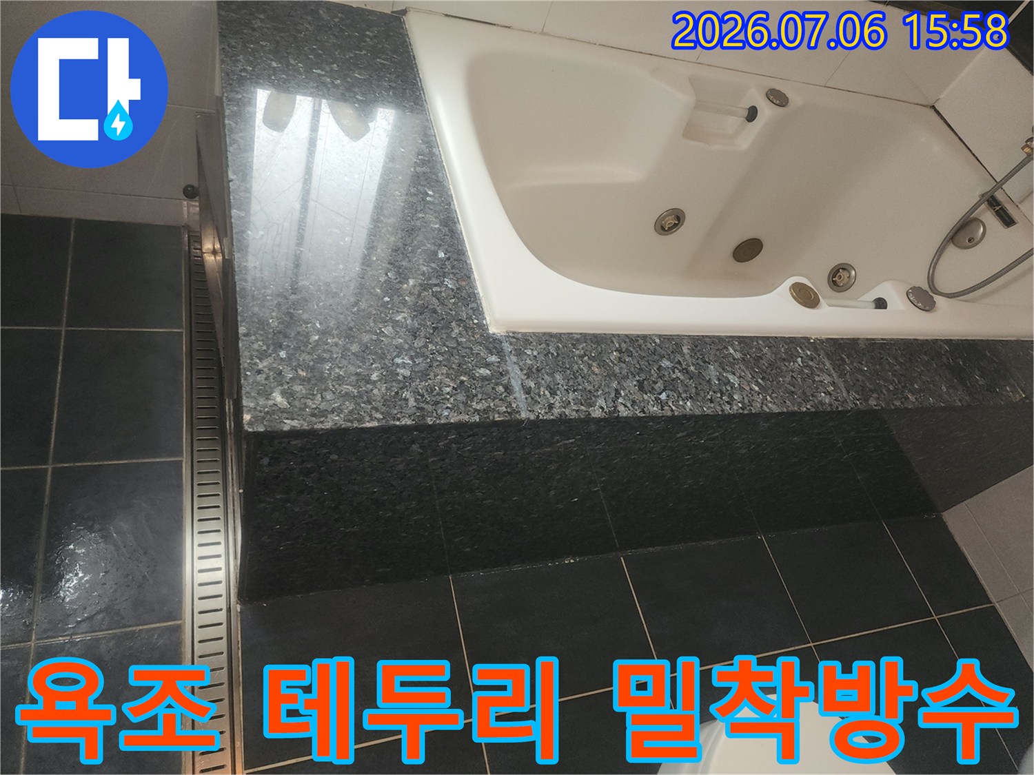 흰색 월풀 욕조와 어두운 계열 마감재의 접합부 시공