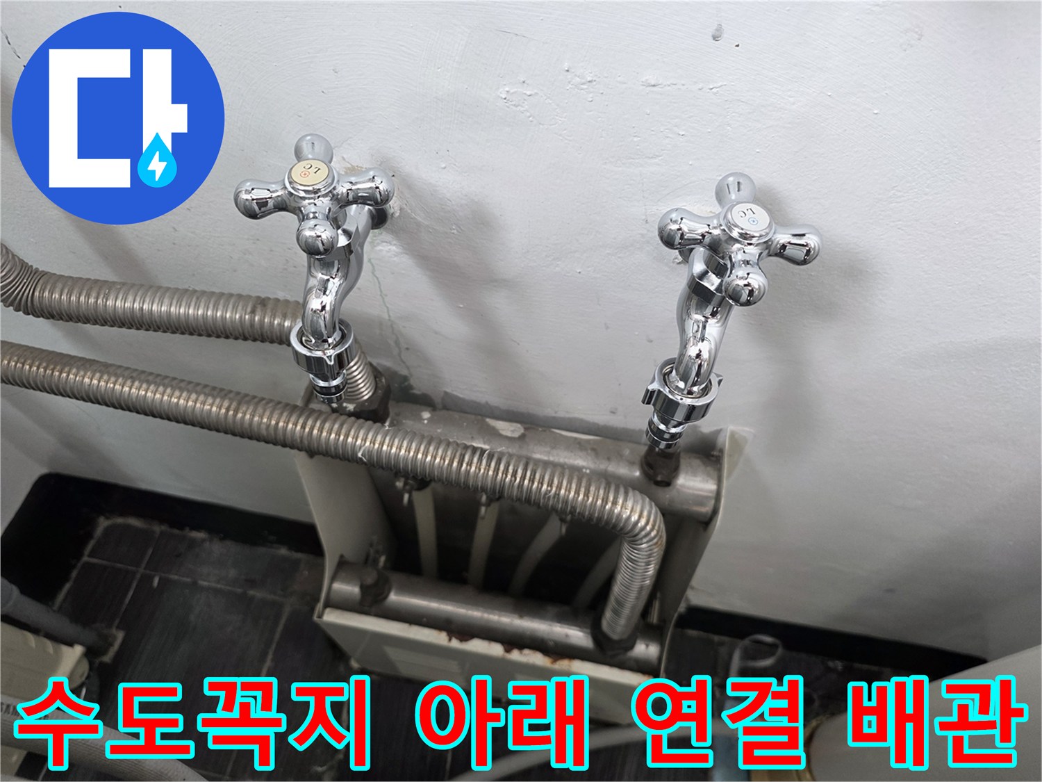 벽면에 고정된 수전과 은색 호스들의 정면 모습