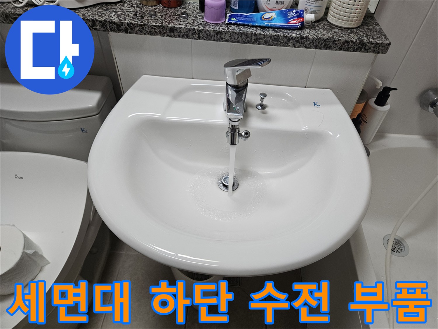 세면대 아래 설치된 은색 수전과 연결 호스 상세 모습입니다.