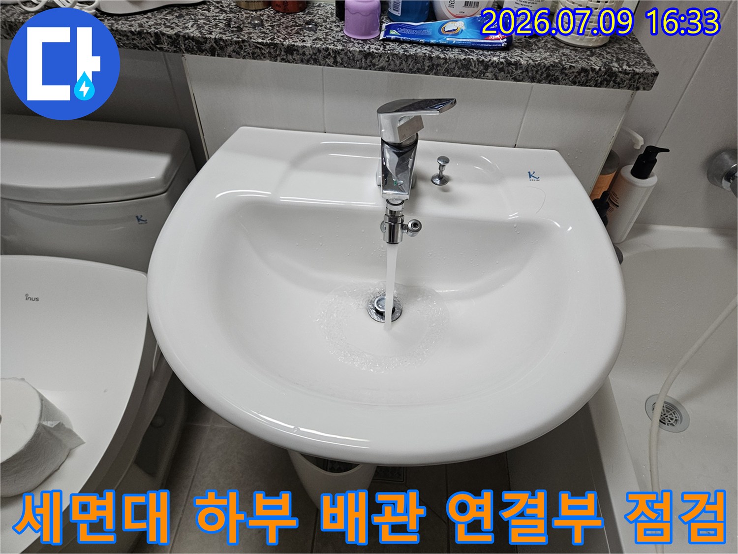 세면대 아래쪽 금속 재질의 트랩과 배수 호스 연결 부위 상세 촬영
