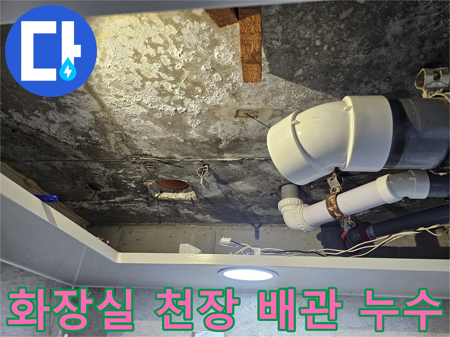 누수로 인해 변색된 천장 콘크리트와 흰색 배관 구조