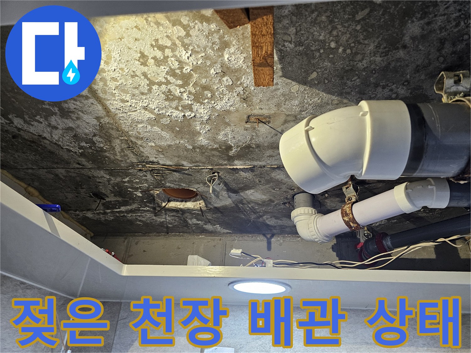 물에 젖어 하얗게 일어난 콘크리트와 PVC 배관 연결부