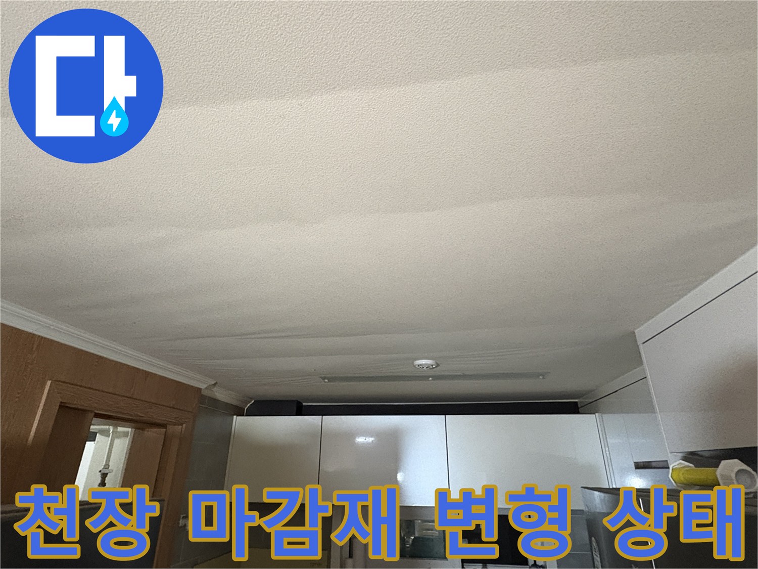 습기로 인해 물결 모양으로 굴곡이 생긴 주방 천장 사진입니다.