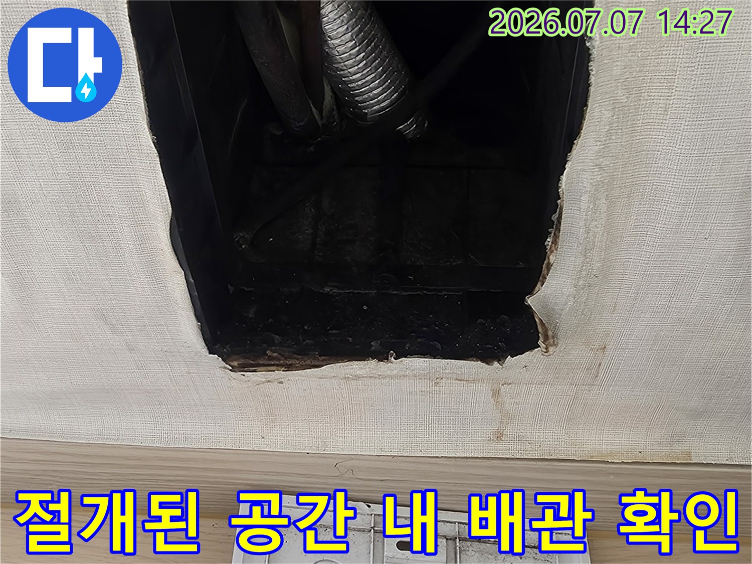 천장 마감재를 제거하고 내부 에어컨용 드레인 호스와 배관을 점검하는 장면
