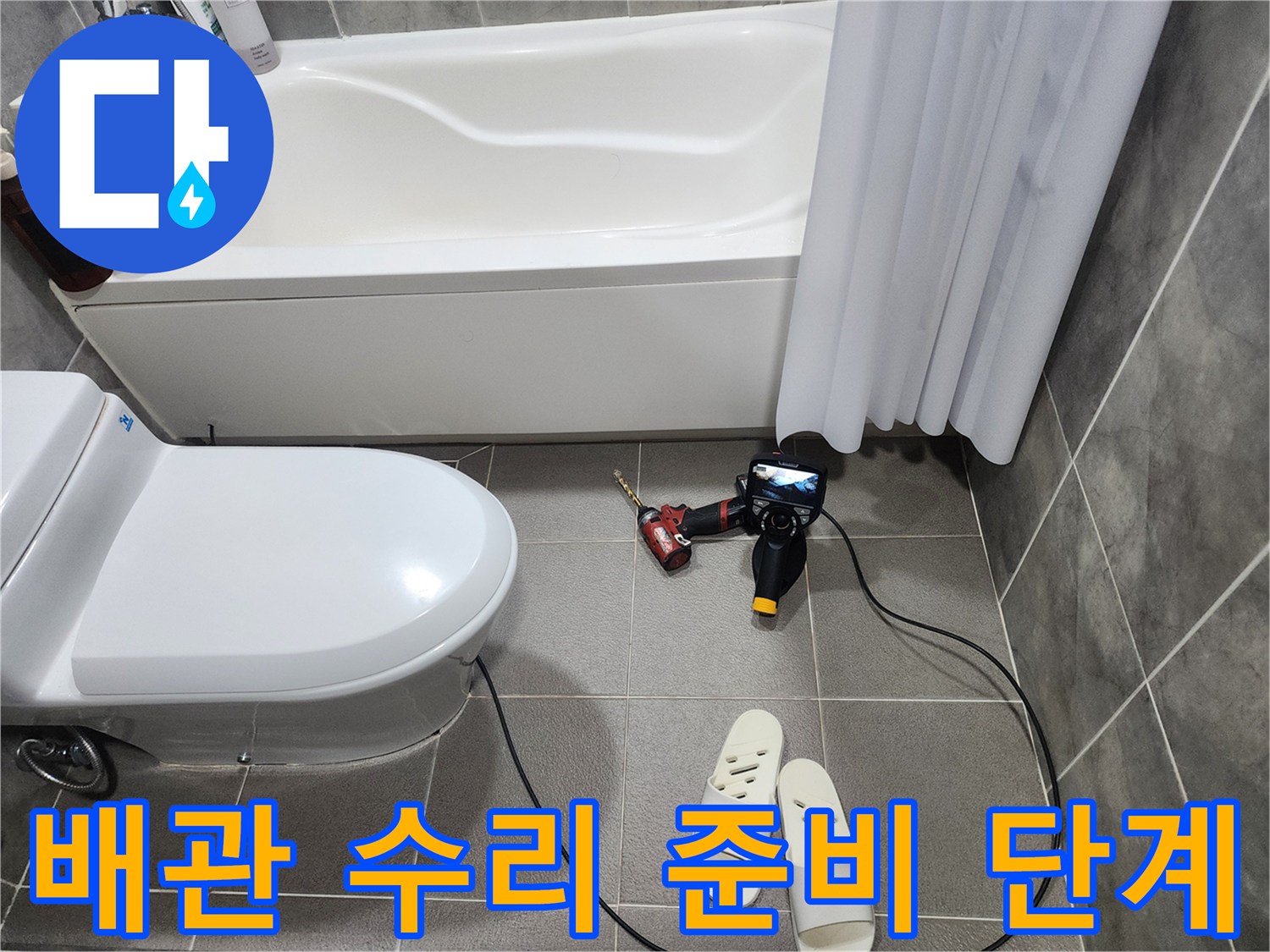 변기 옆에 놓인 전동 드릴과 공구 세트