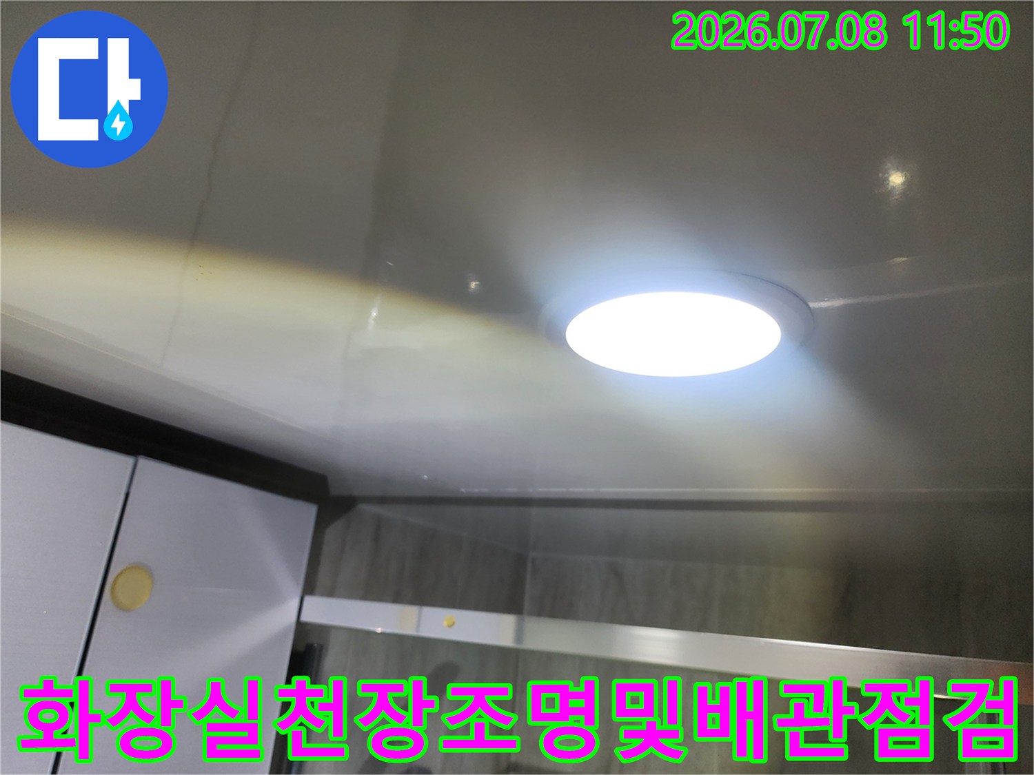 화장실 천장 내부에 설치된 조명과 배관 주변의 누수 여부를 점검하는 모습
