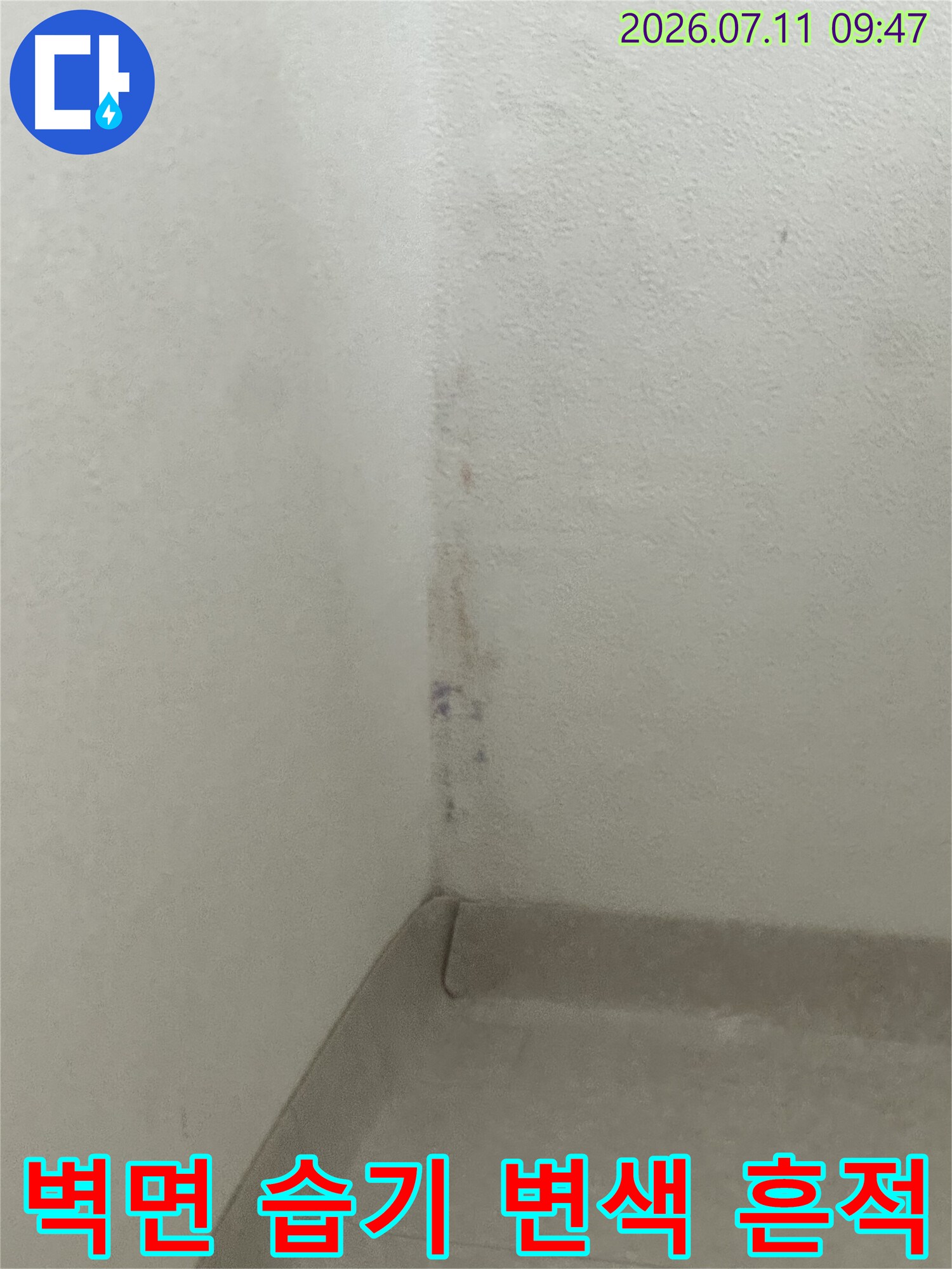 벽면 모서리 부분에 발생한 수분 누출로 인한 변색과 오염 흔적