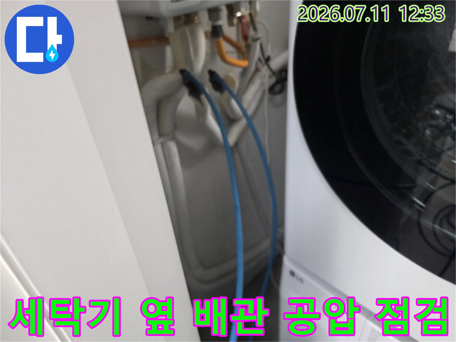 세탁기 옆에 위치한 파란색 배관에 장비를 연결하여 압력을 체크하는 모습