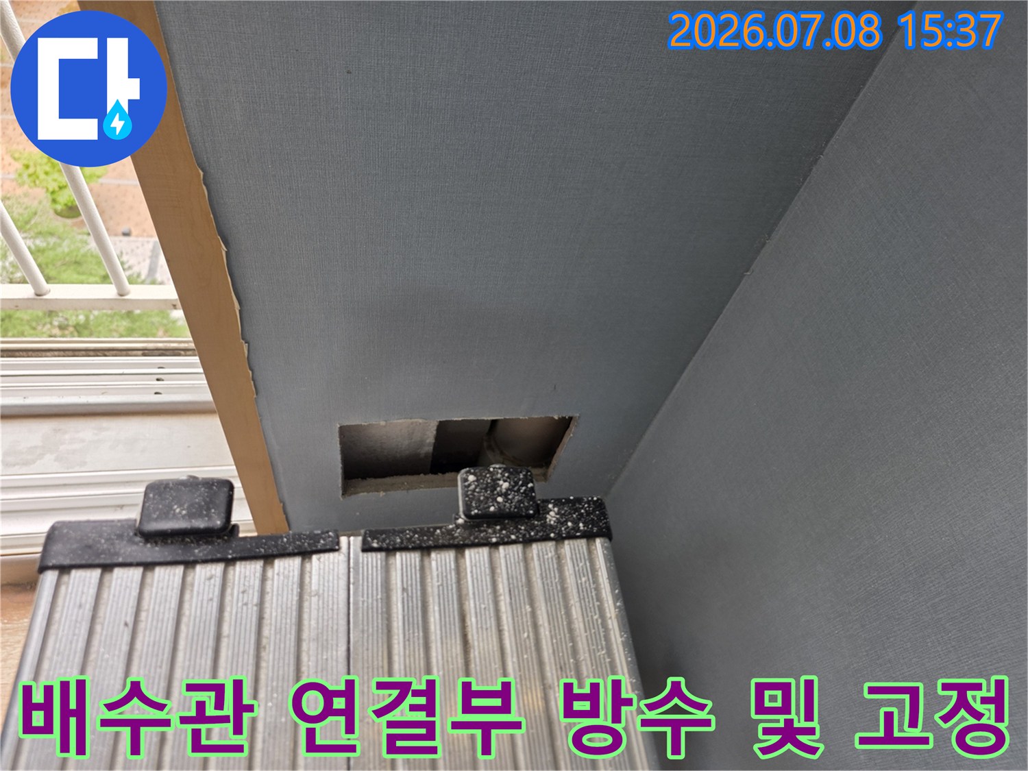 에어컨 배수 호스 연결 지점의 누수를 차단하기 위해 금속 밴드로 강화한 공사 현장