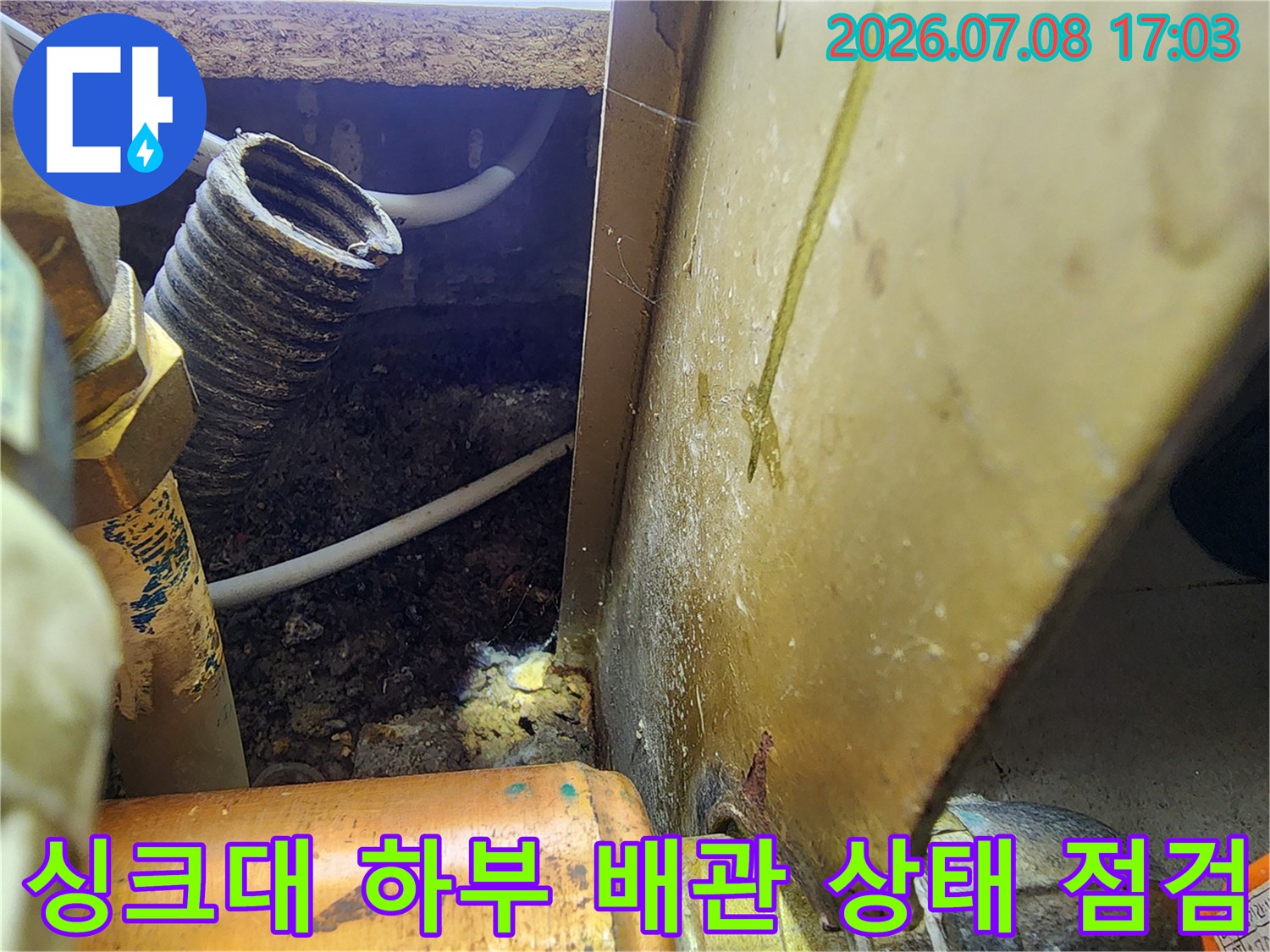 싱크대 밑 공간의 노출된 배관과 주변 습기 오염 현장