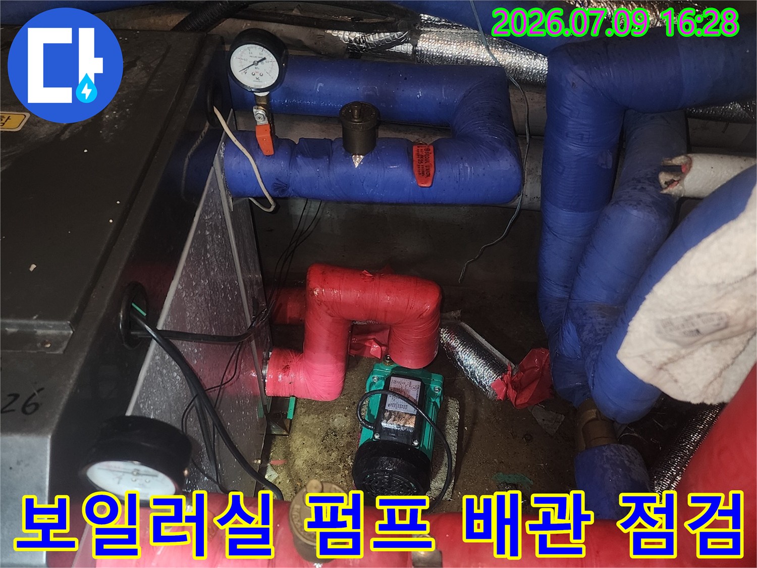 보일러실 내부에 설치된 빨간색과 파란색 배관 및 순환 펌프 부위 점검