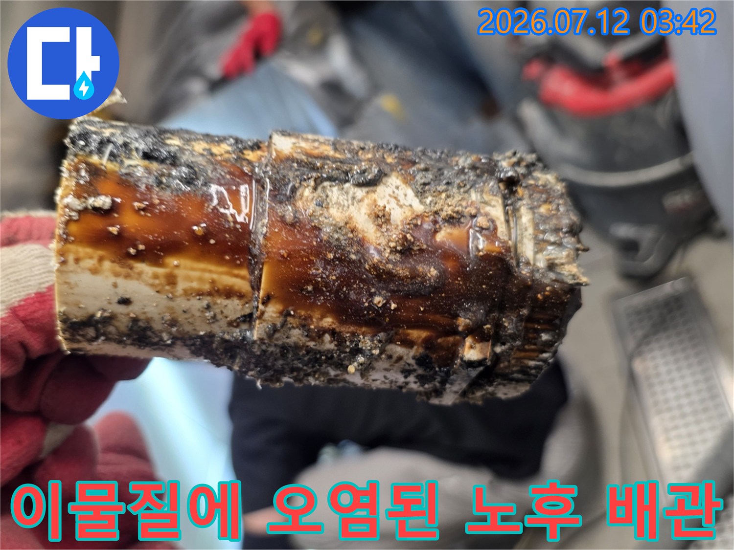 변색되고 기름 찌꺼기가 고착된 파손 상태의 배출관