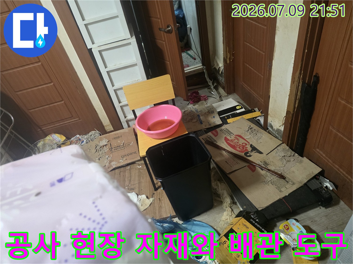 누수 공사 중인 현장에서 사용되는 대형 용기와 각종 작업용품들