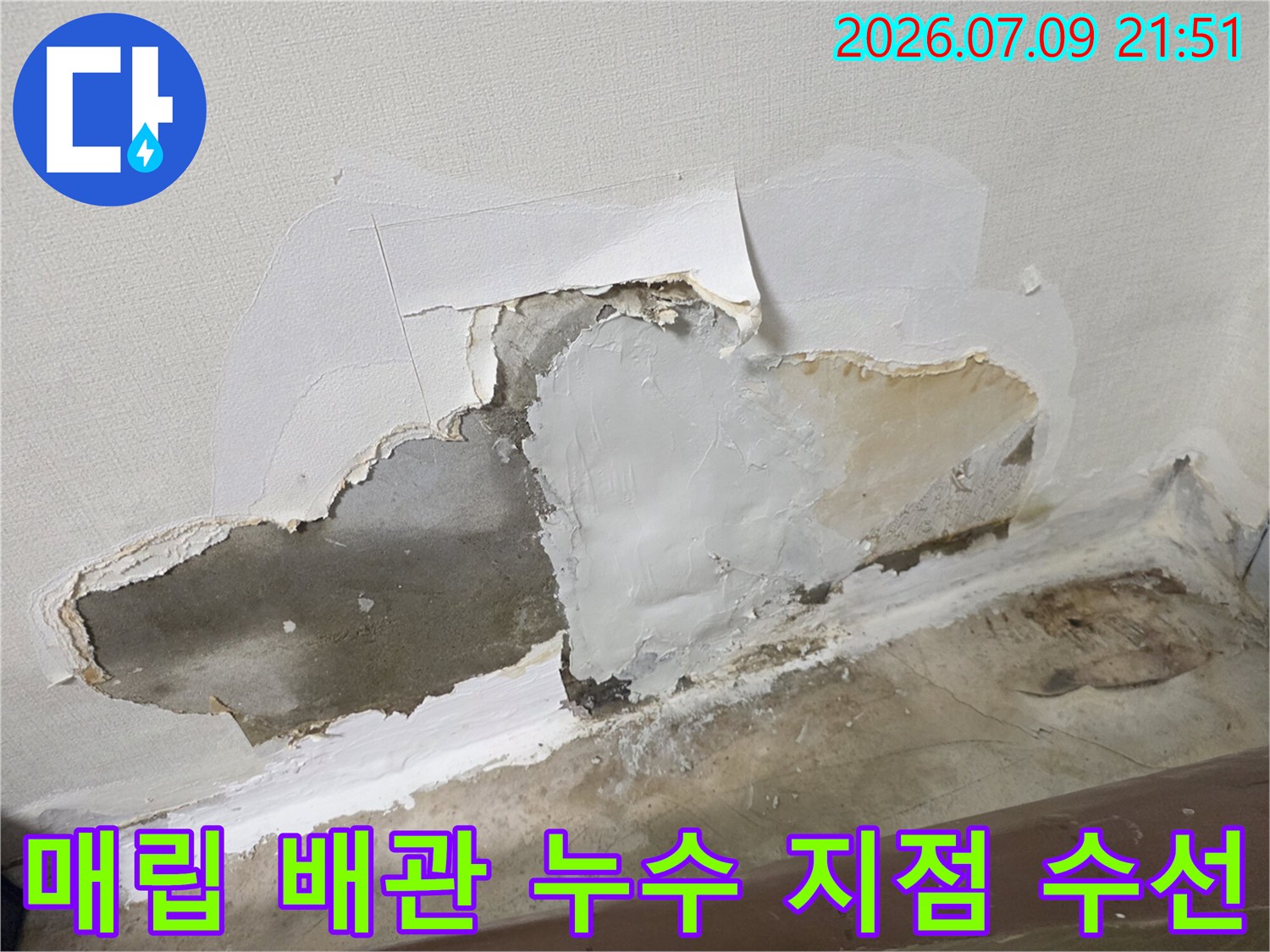 벽면을 뜯어내고 노출된 배관의 손상 부위를 교체한 현장 사진입니다.