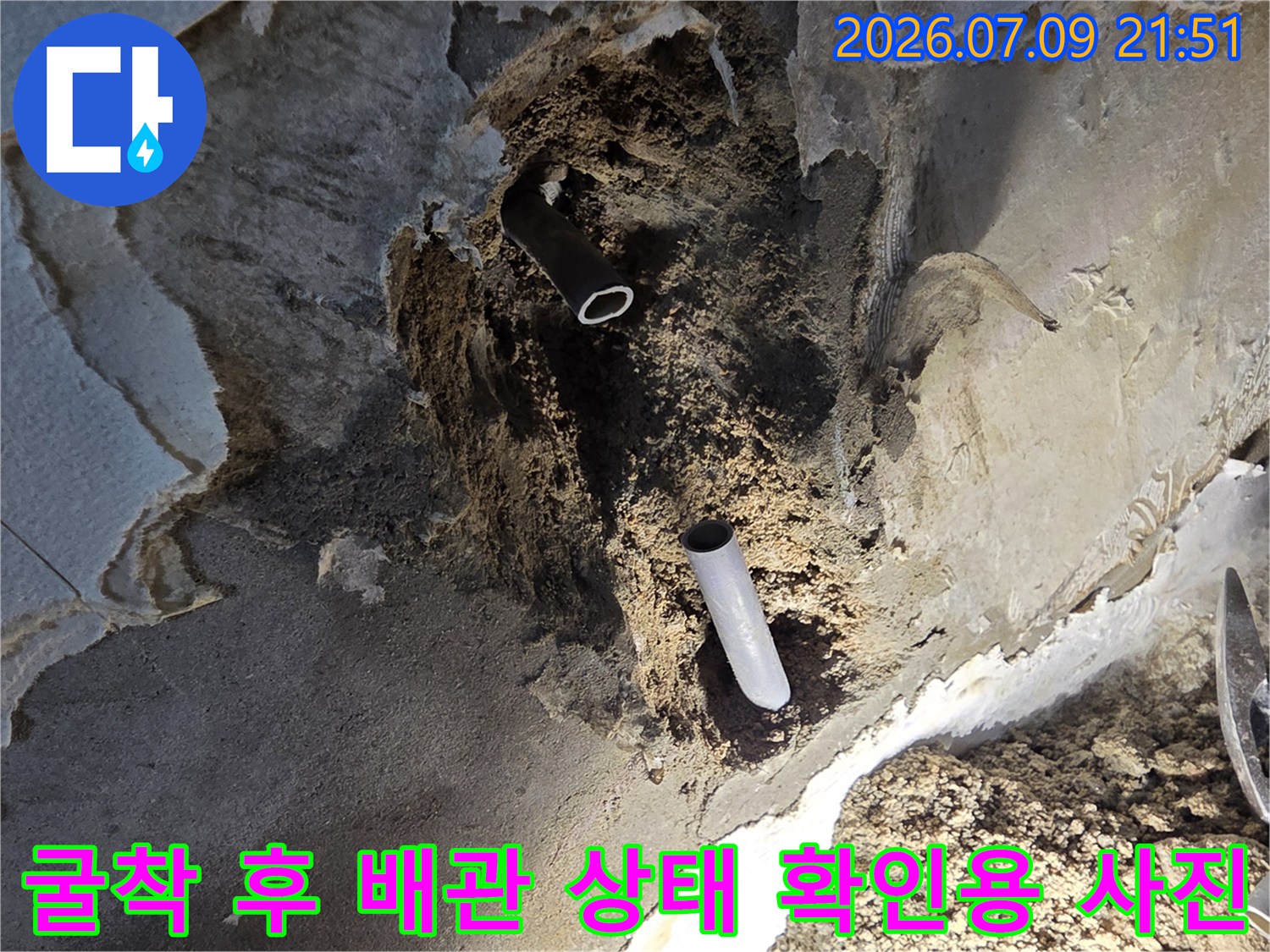 벽면을 파내어 노출된 수도 연결부와 손상 부위의 현장 모습