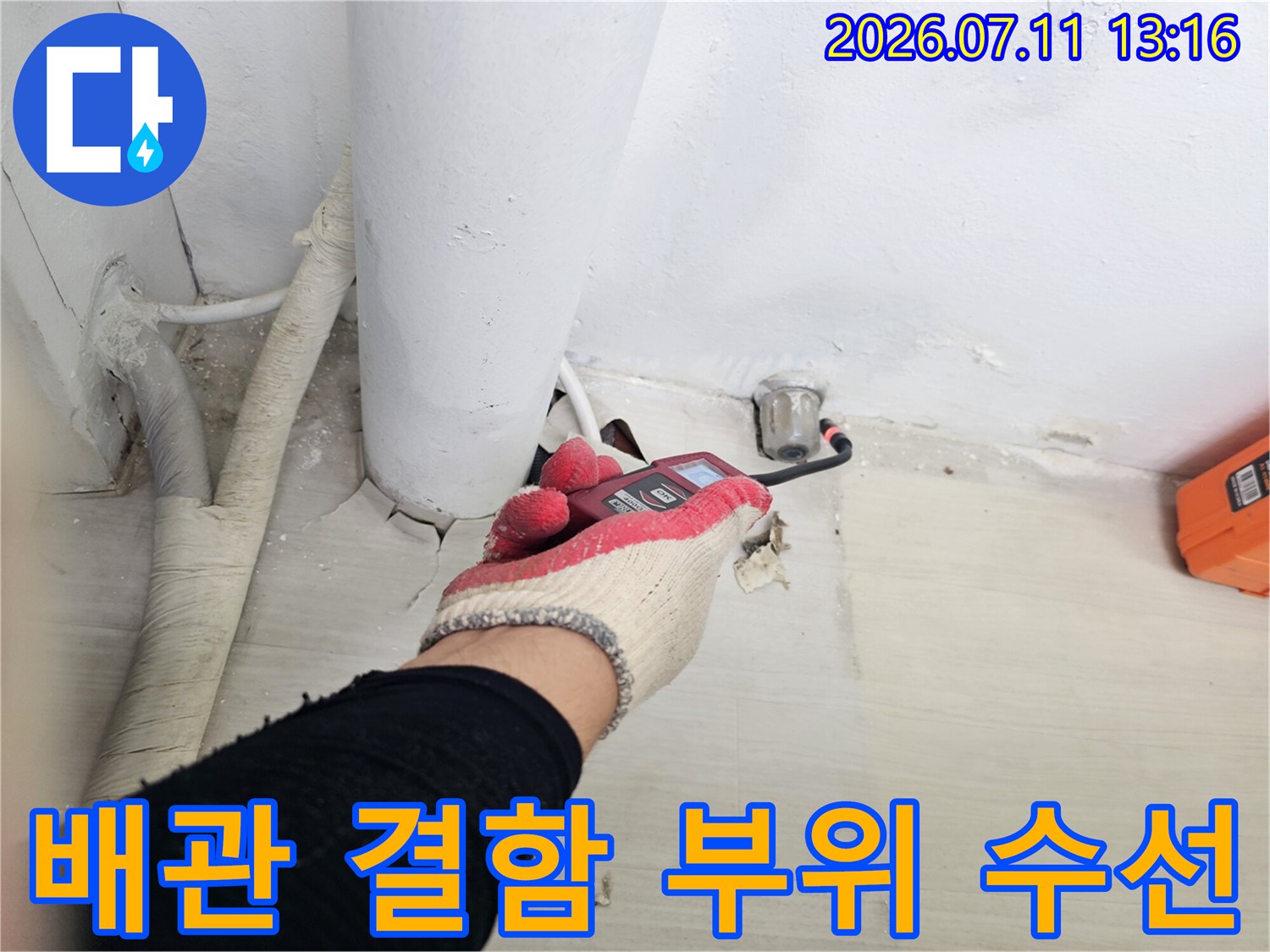 작업자가 장갑을 끼고 베란다 배관 연결부의 노후 상태를 점검하는 모습